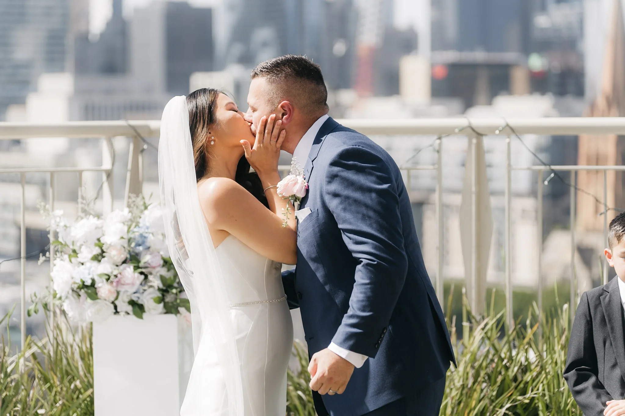 Che and Rob kissing during their rooftop ceremony