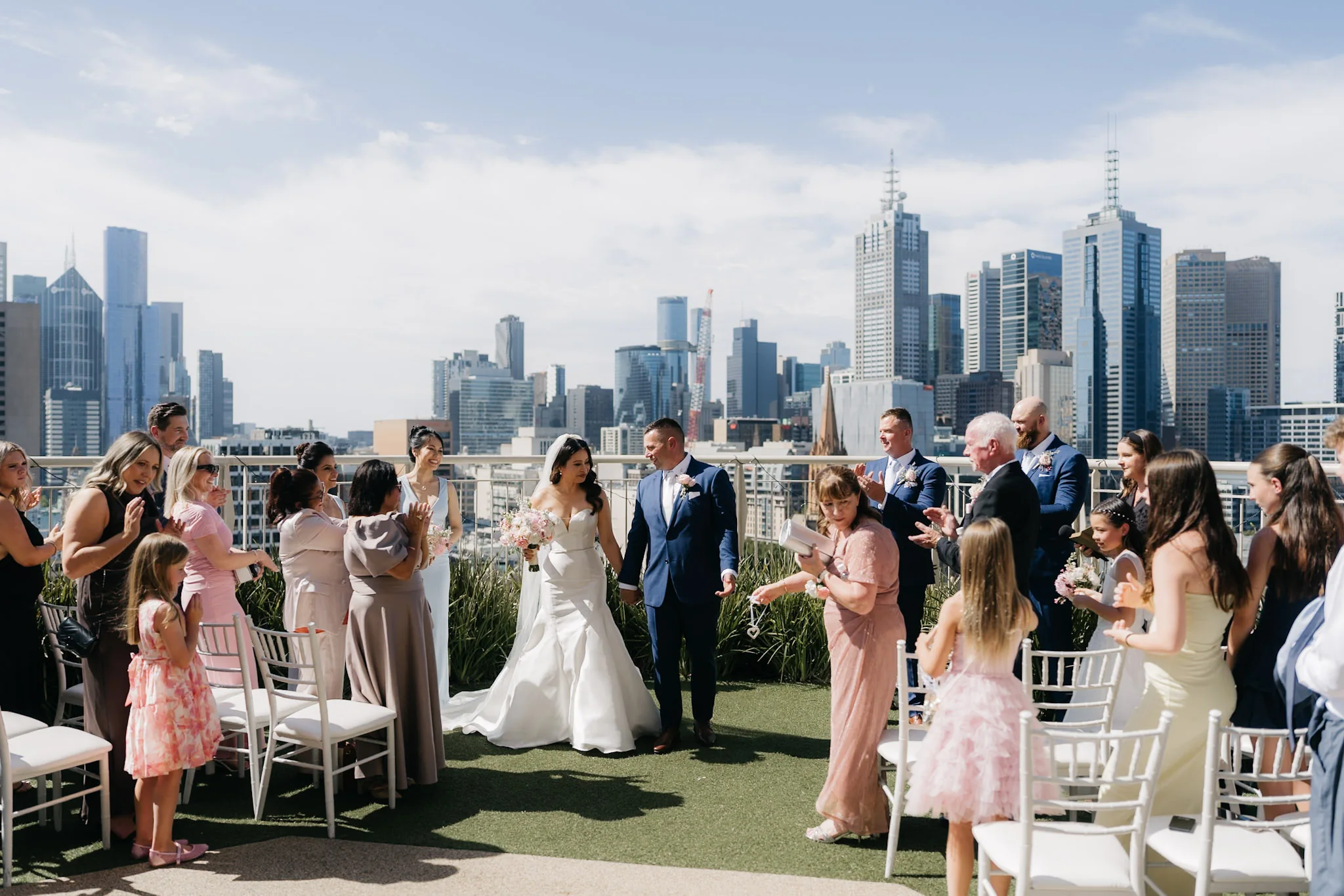 Guests celebrating as Che and Rob walk back along the rooftop aisle