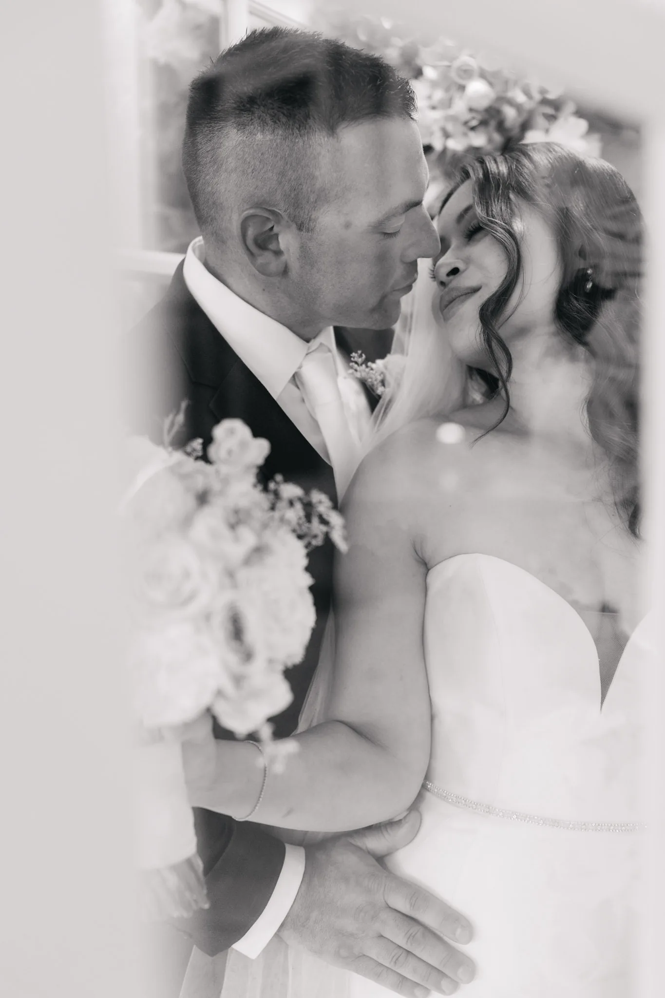 A black-and-white portrait of Che and Rob beneath her veil