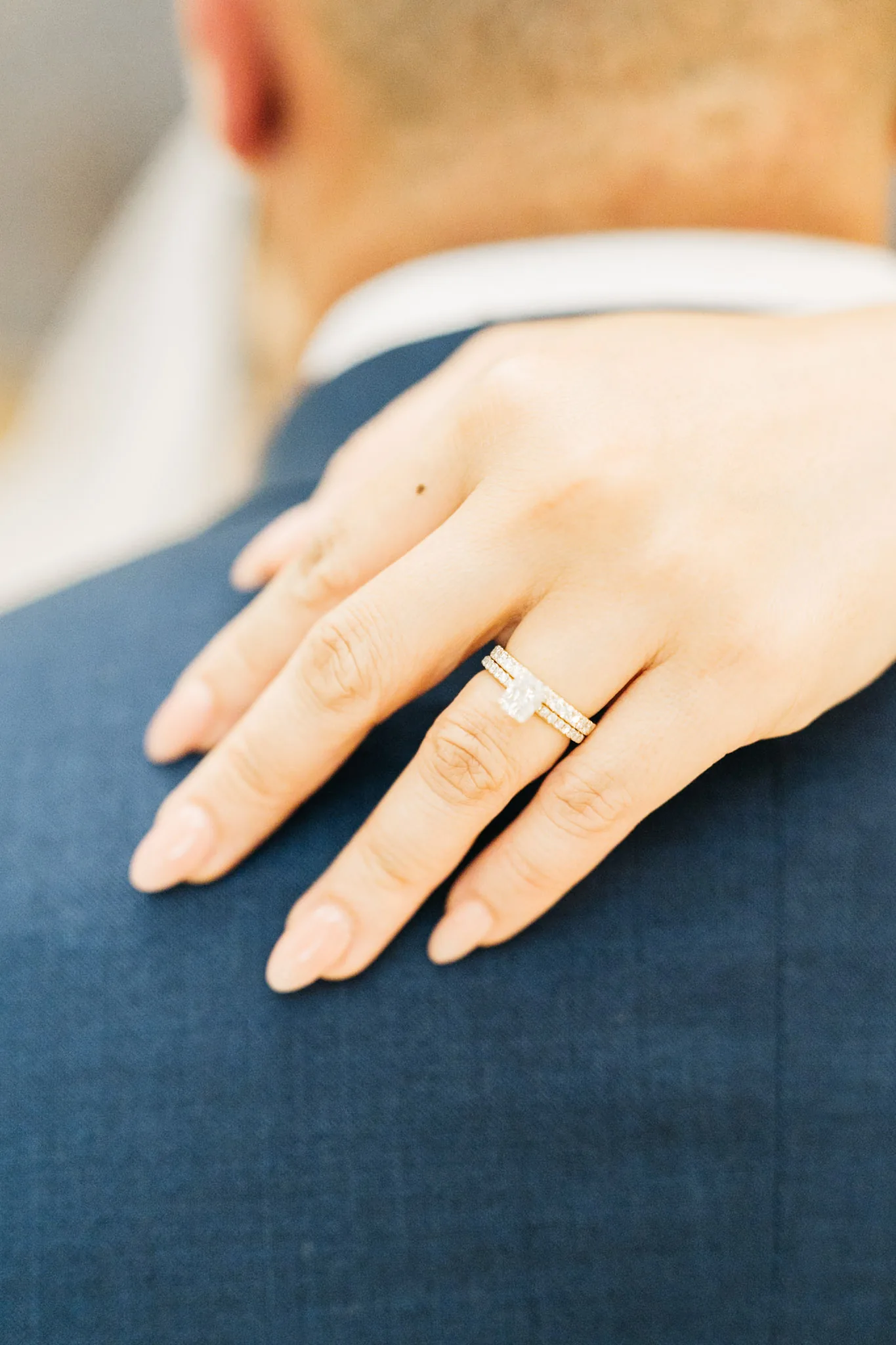 Che's wedding rings against Rob's blue suit