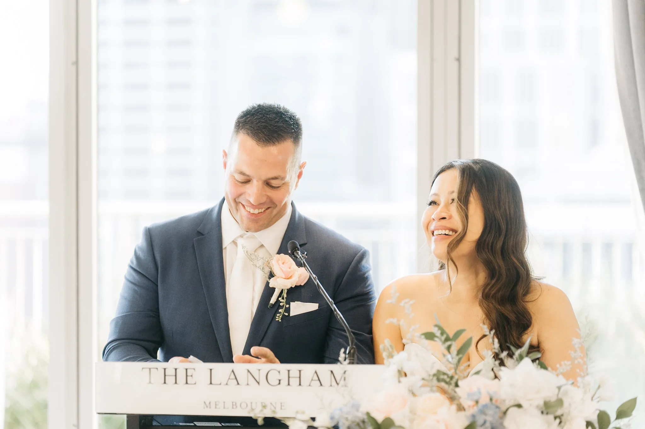 Rob and Che laughing together behind the reception lectern