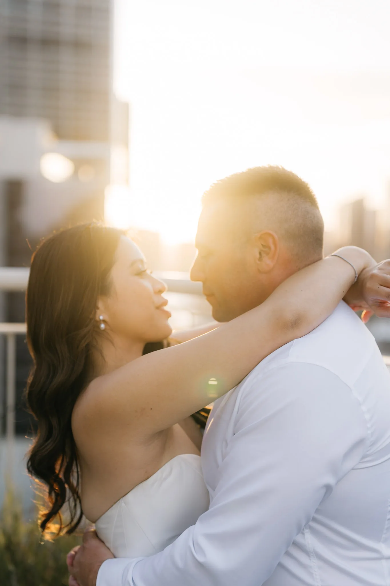 Warm sunset light falling across Che and Rob as they embrace