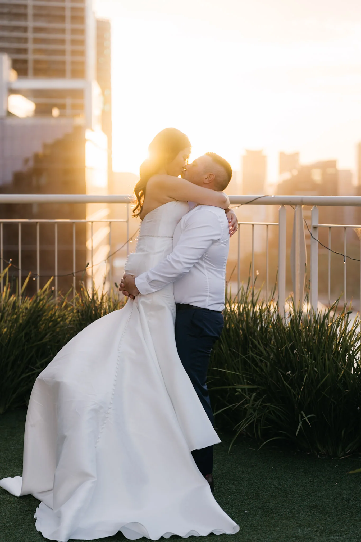 Rob lifting Che into an embrace in the golden evening light