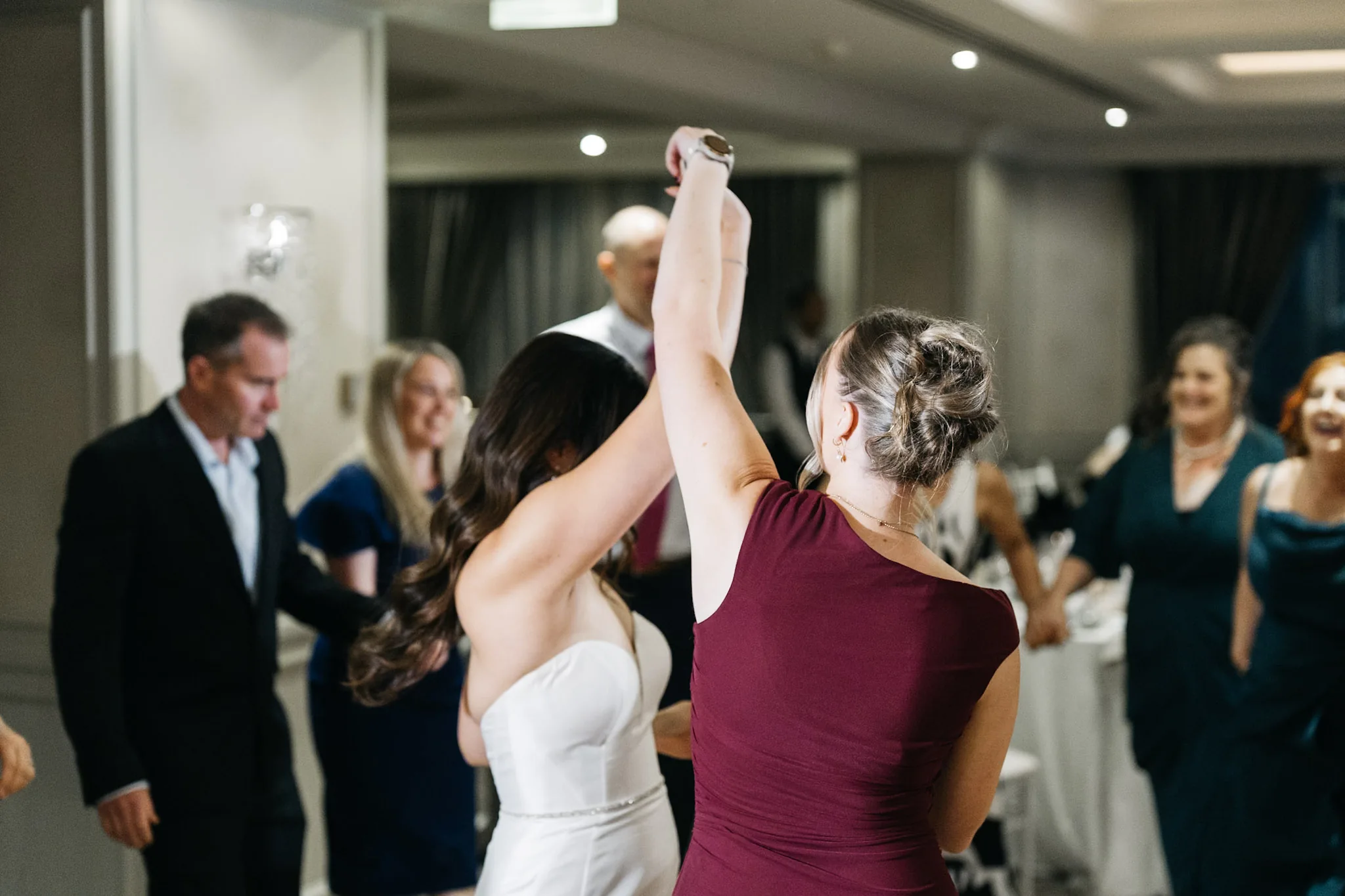 Che and a friend raising their hands as they dance