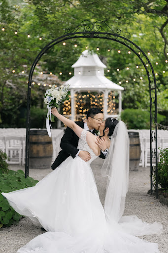 The groom dipping Phoebe beneath a garden arch