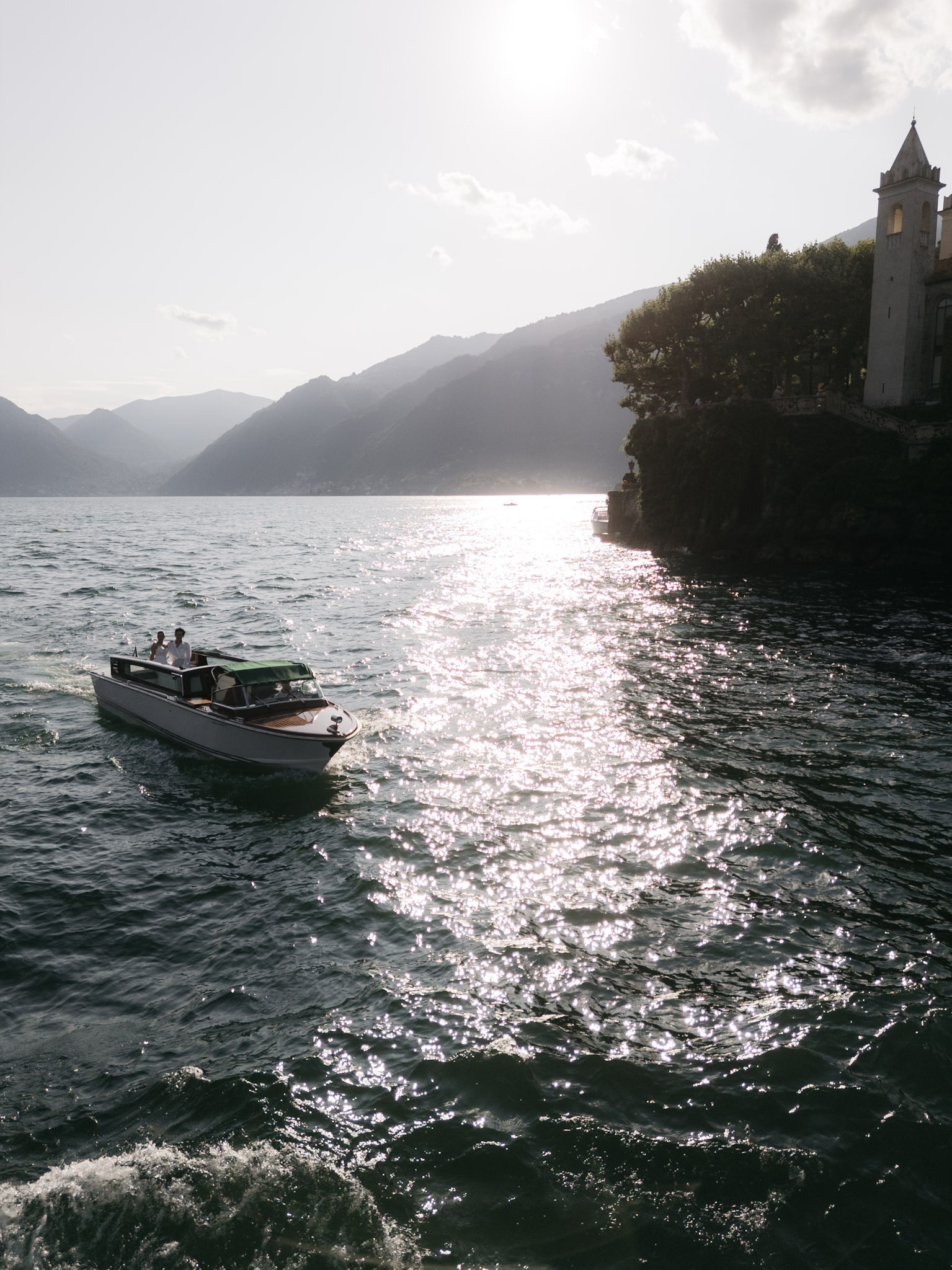 Sunlight glinting across the water as the boat turns