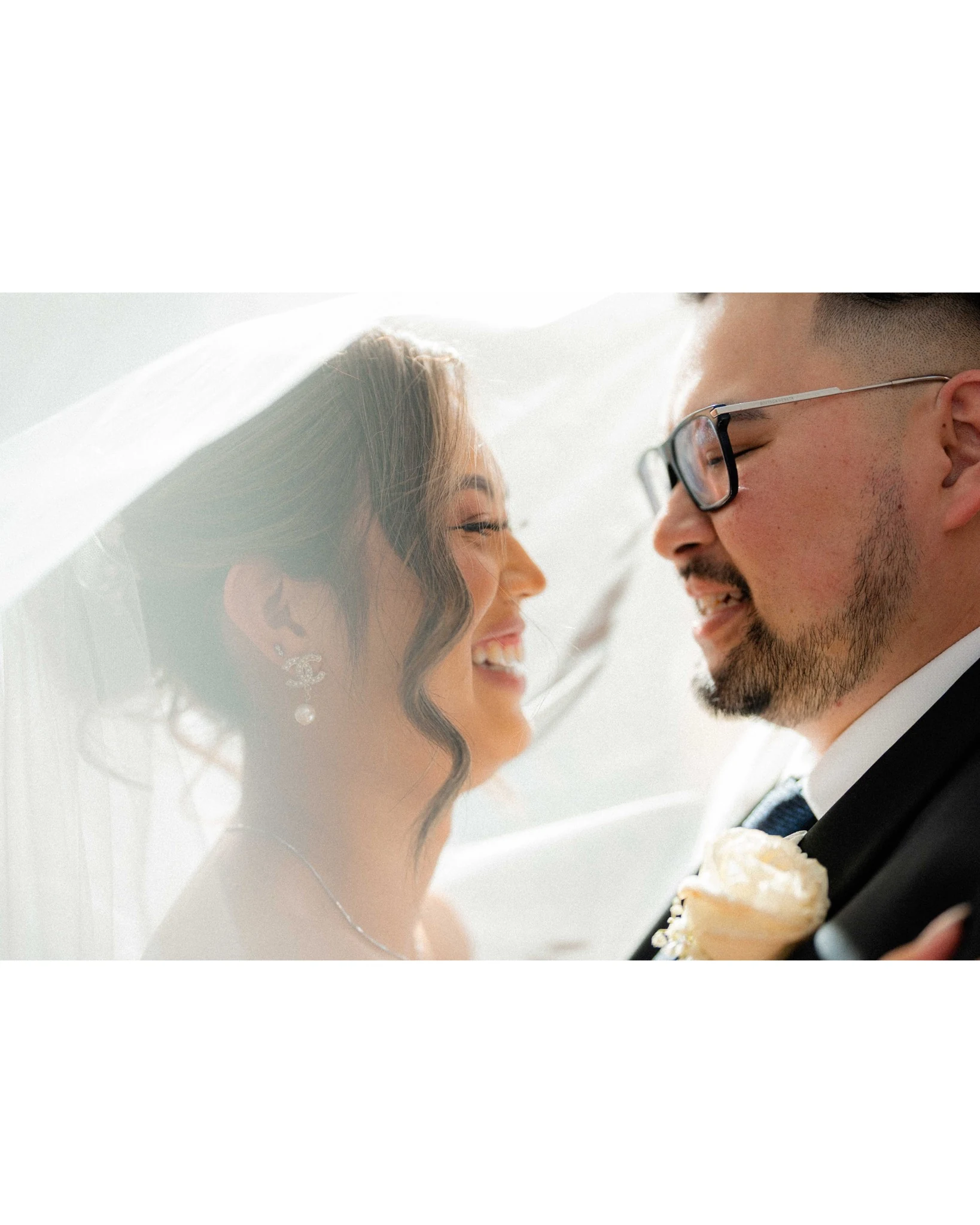 Newlyweds share a bright, joyful kiss in the city.