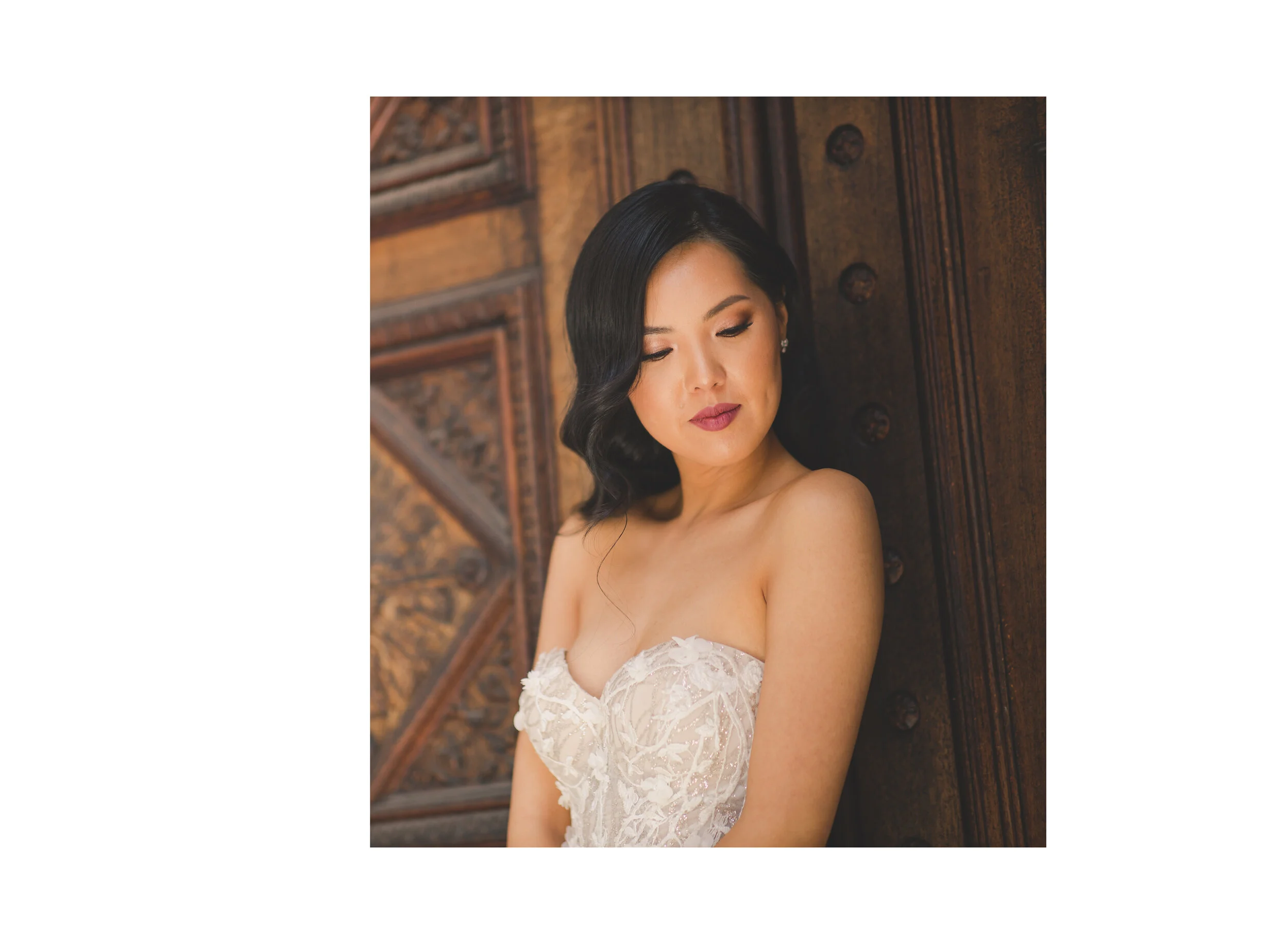 Bride posing beside intricately carved wooden doors