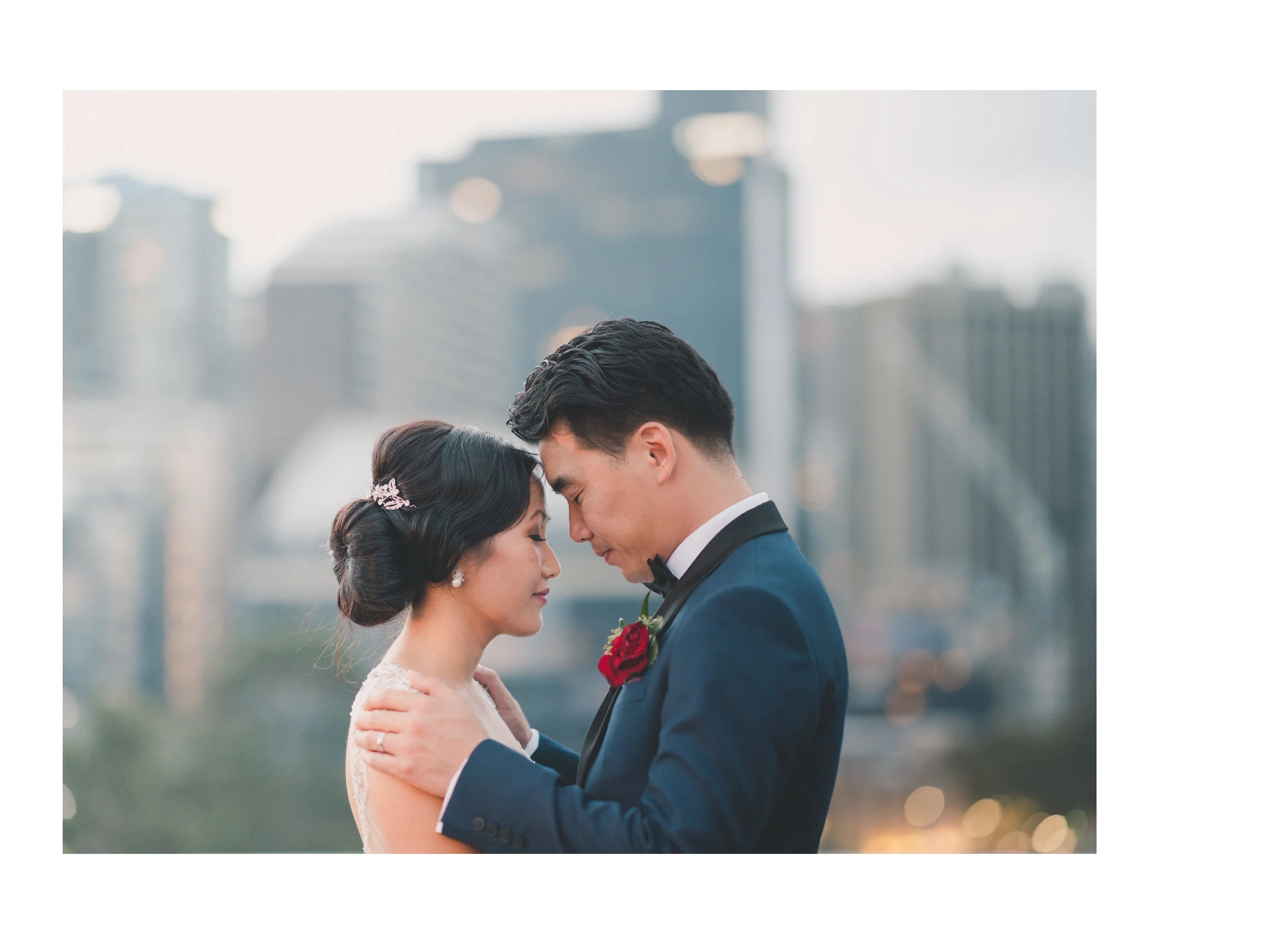 Newlyweds touching foreheads against the Melbourne skyline