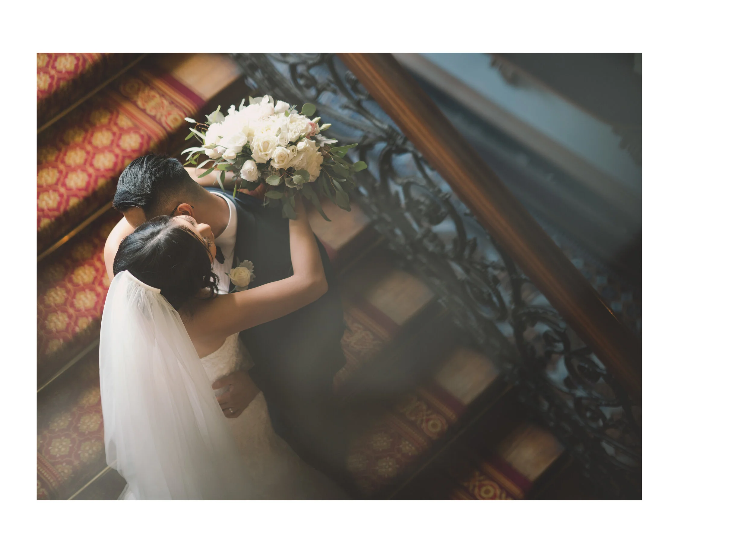 Overhead view of newlyweds embracing on an ornate staircase