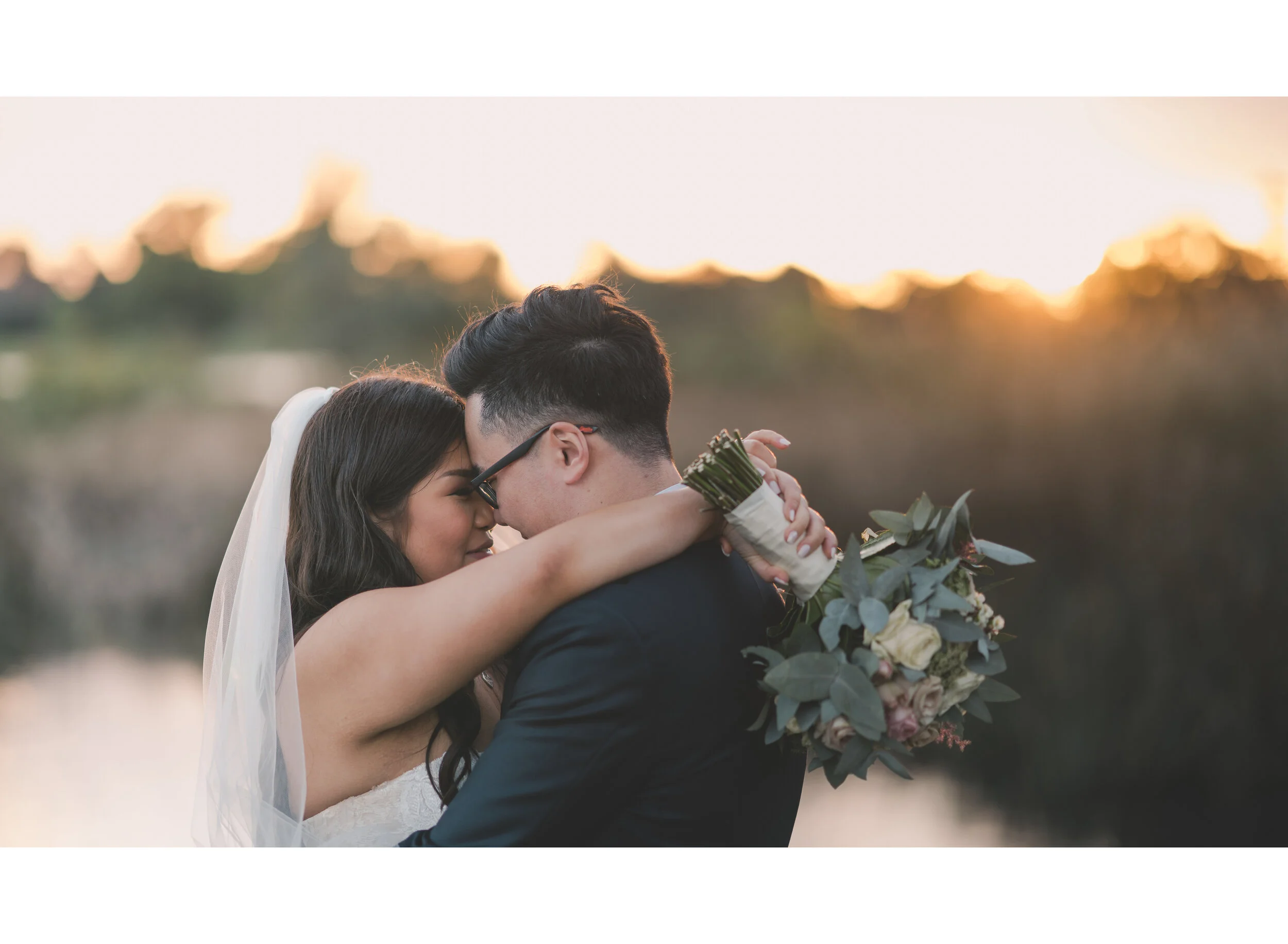 Newlyweds embracing at sunset