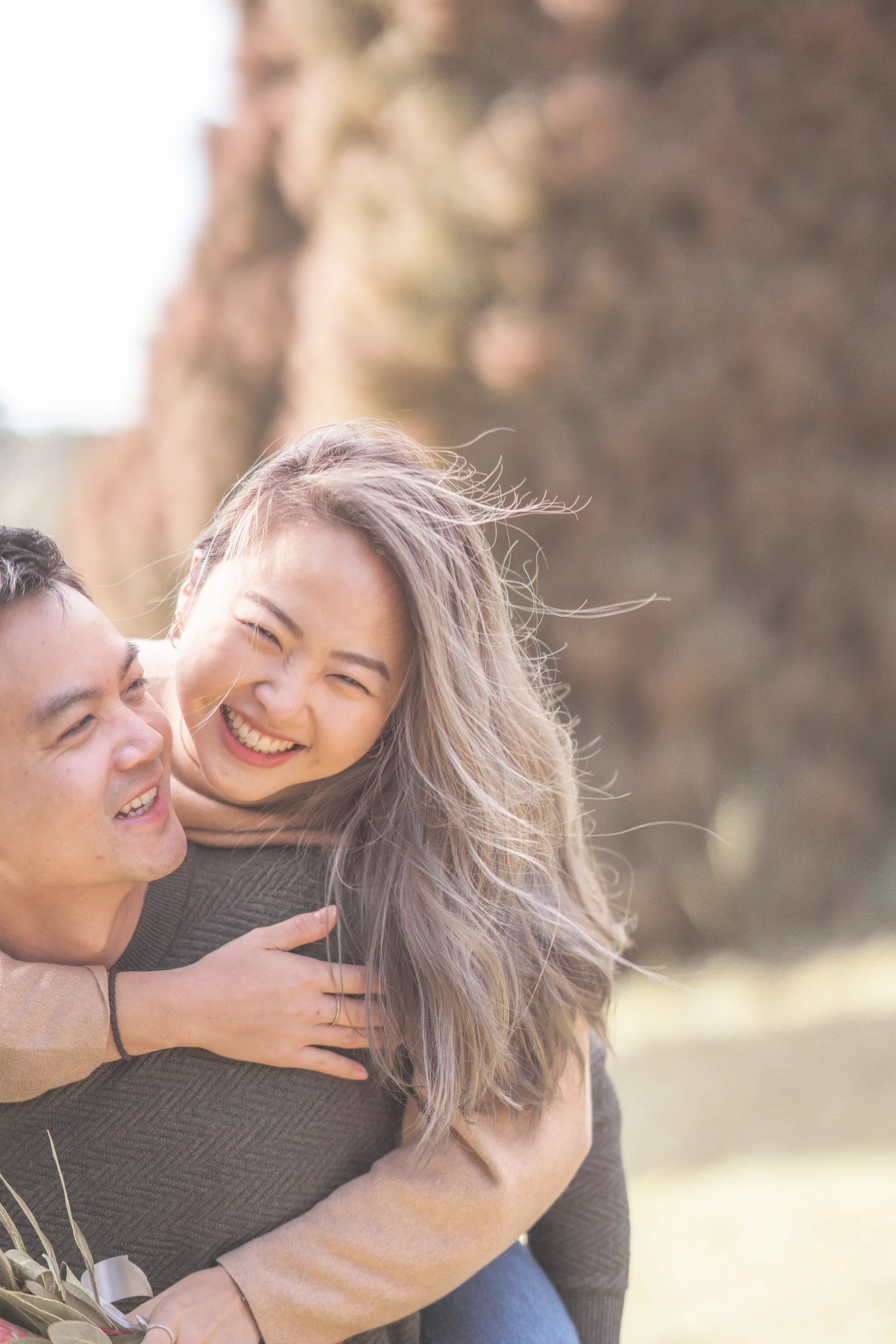 A laughing couple wrapped in a playful embrace