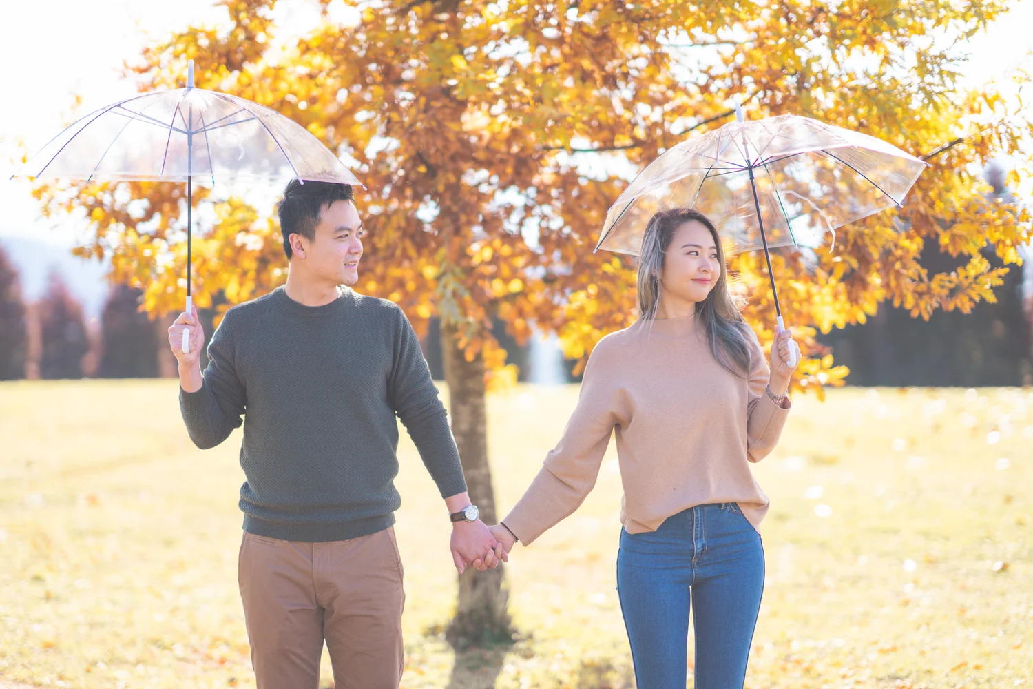 Couple walking beneath glowing autumn trees