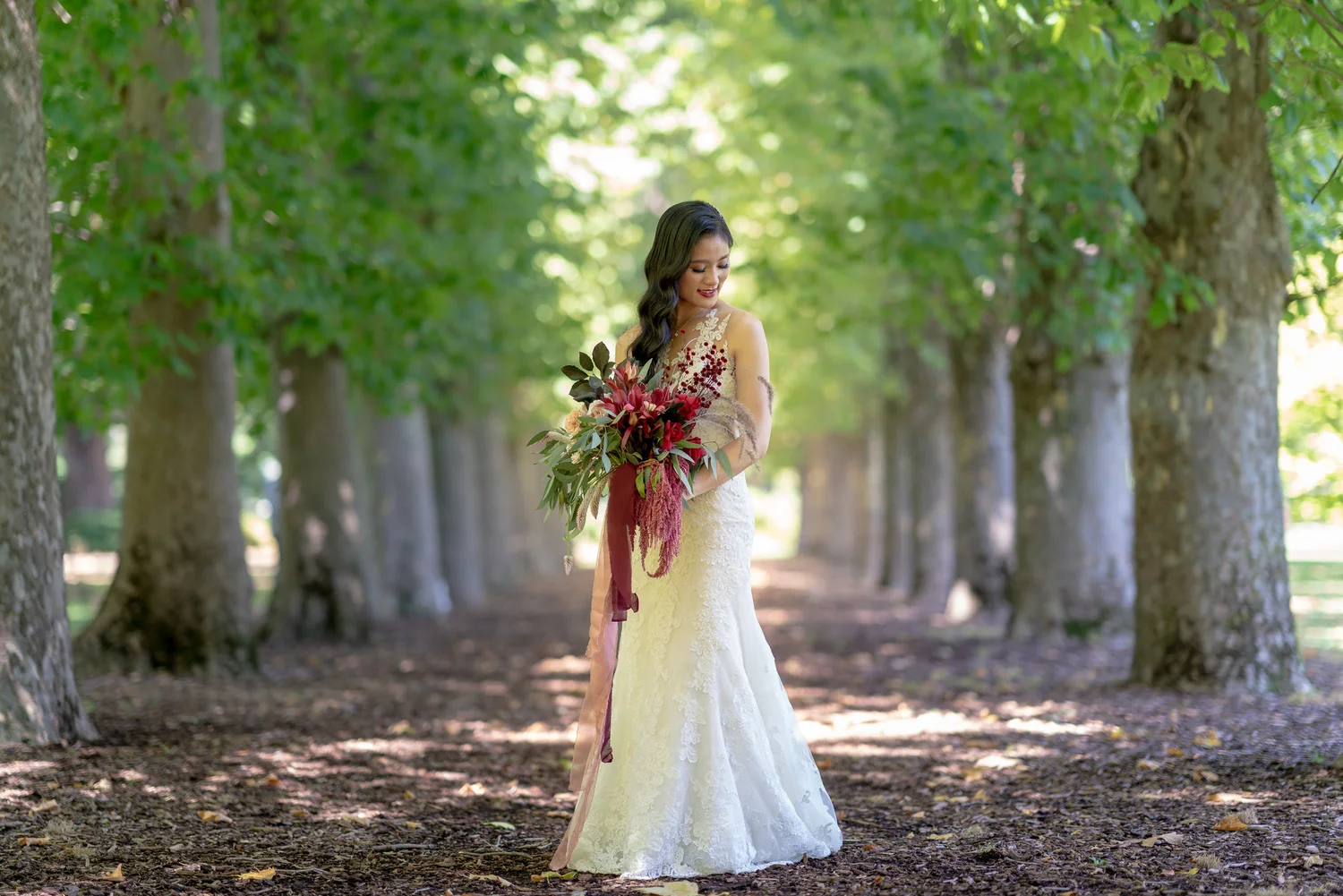 Bride standing among tall green trees