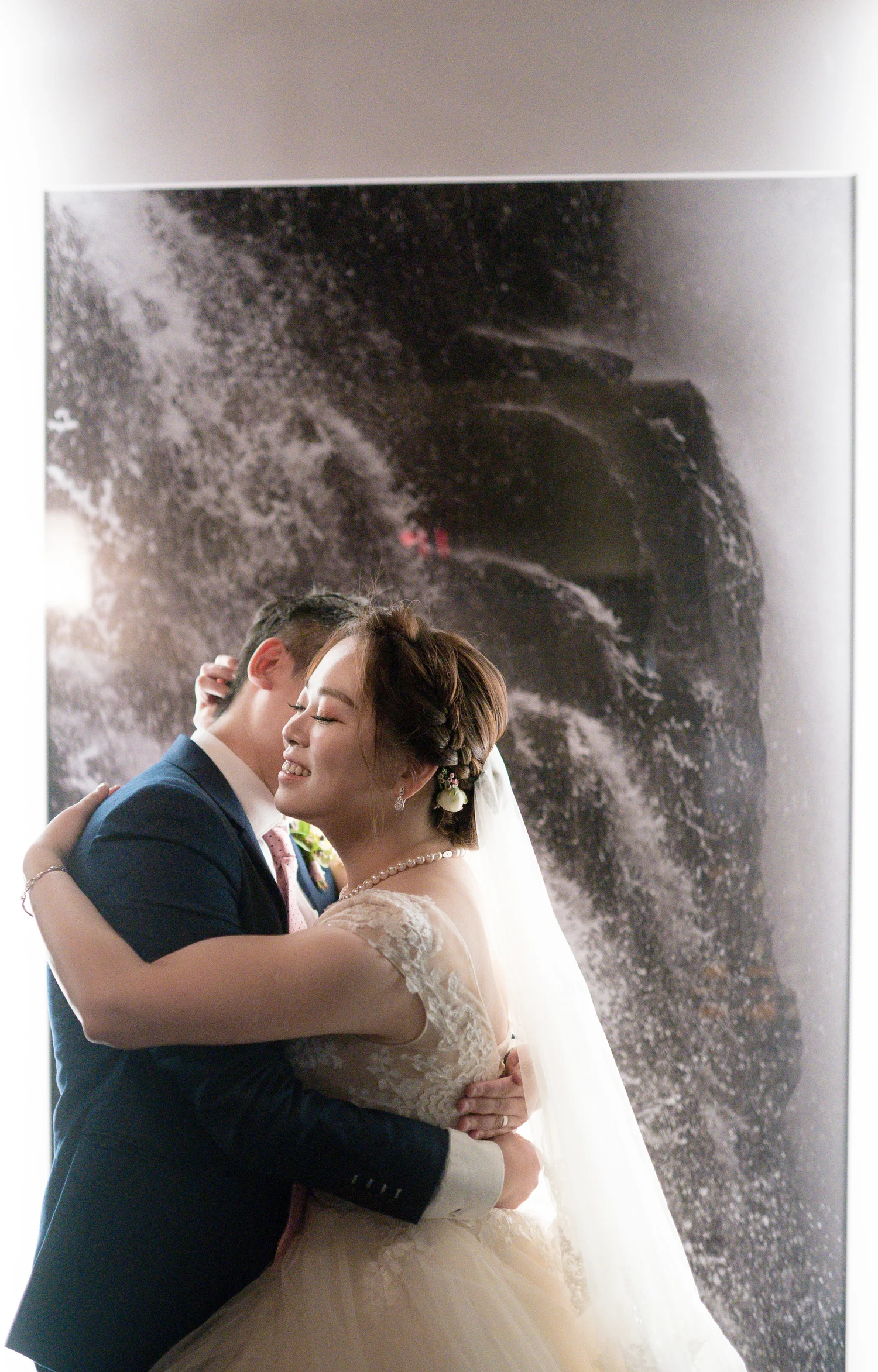 Newlyweds dancing beneath a soft spray of water