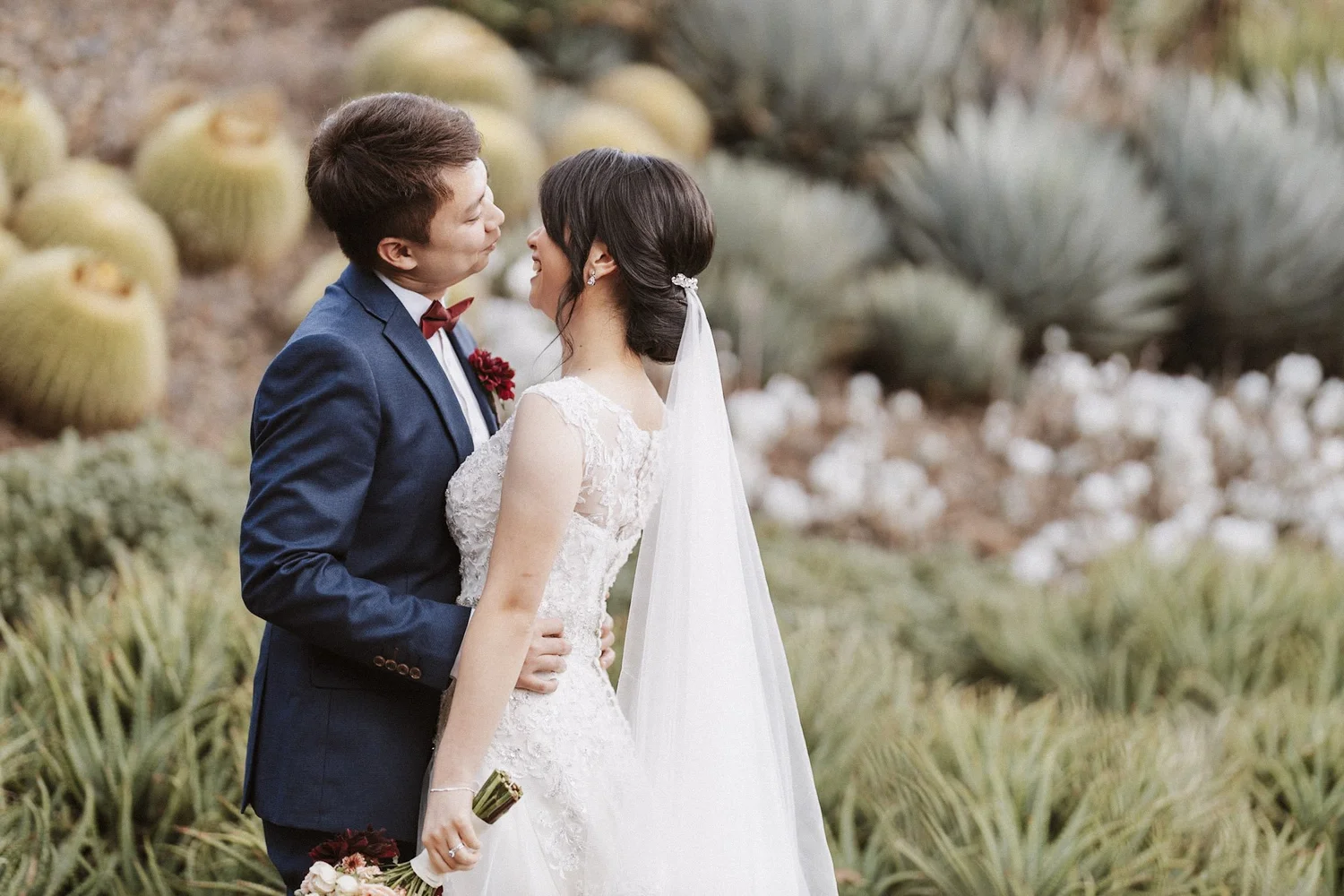 Newlyweds kissing in a sculptural garden