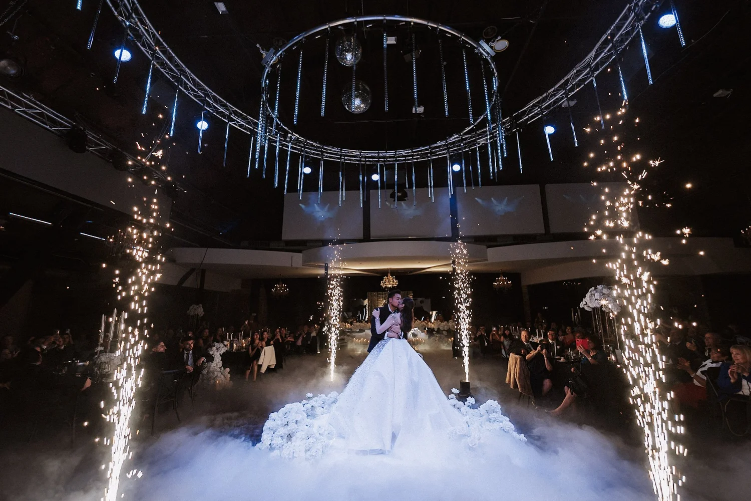 Wedding couple beneath indoor spark fountains