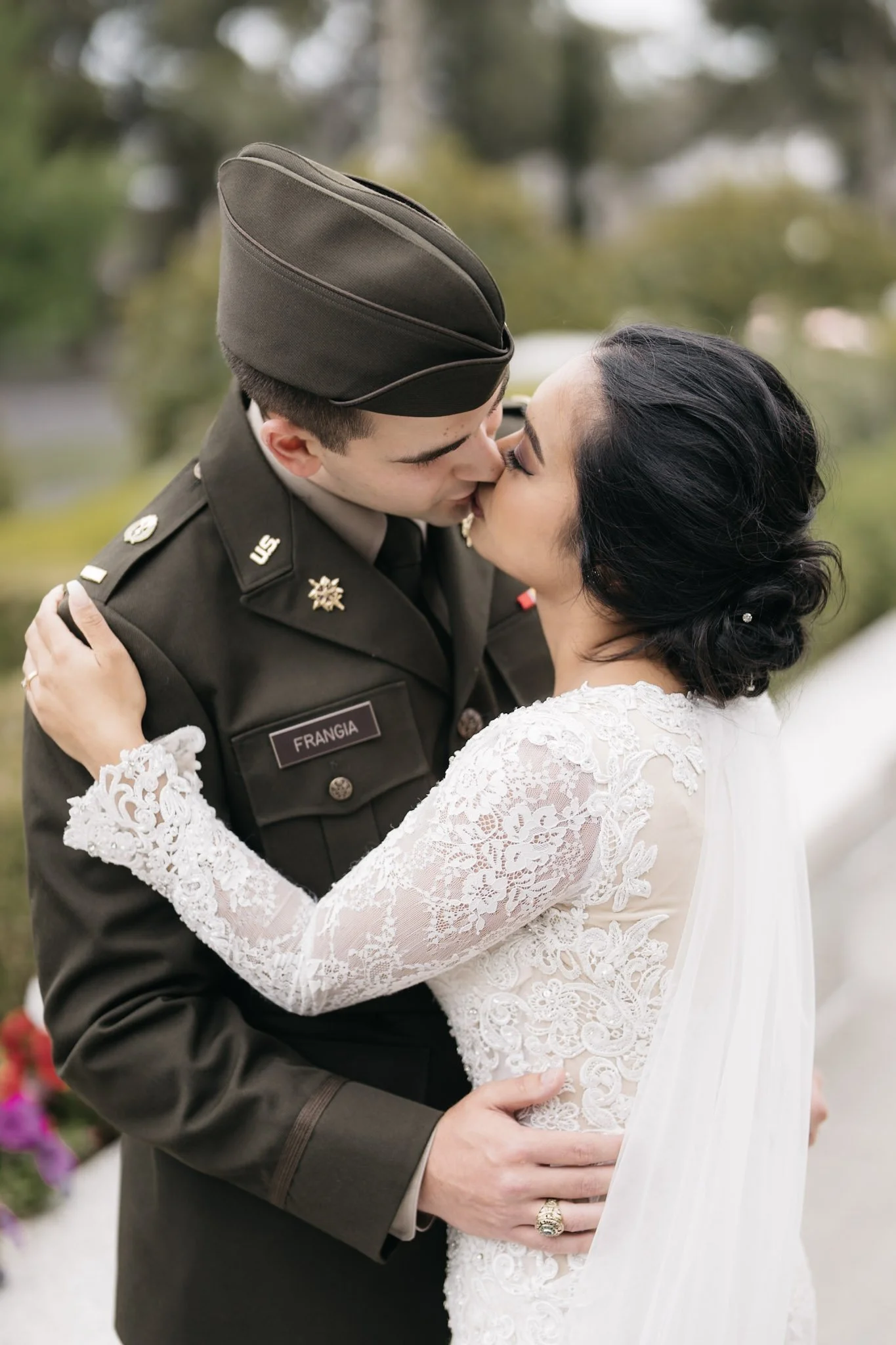 Newlyweds embracing in formal military wedding attire