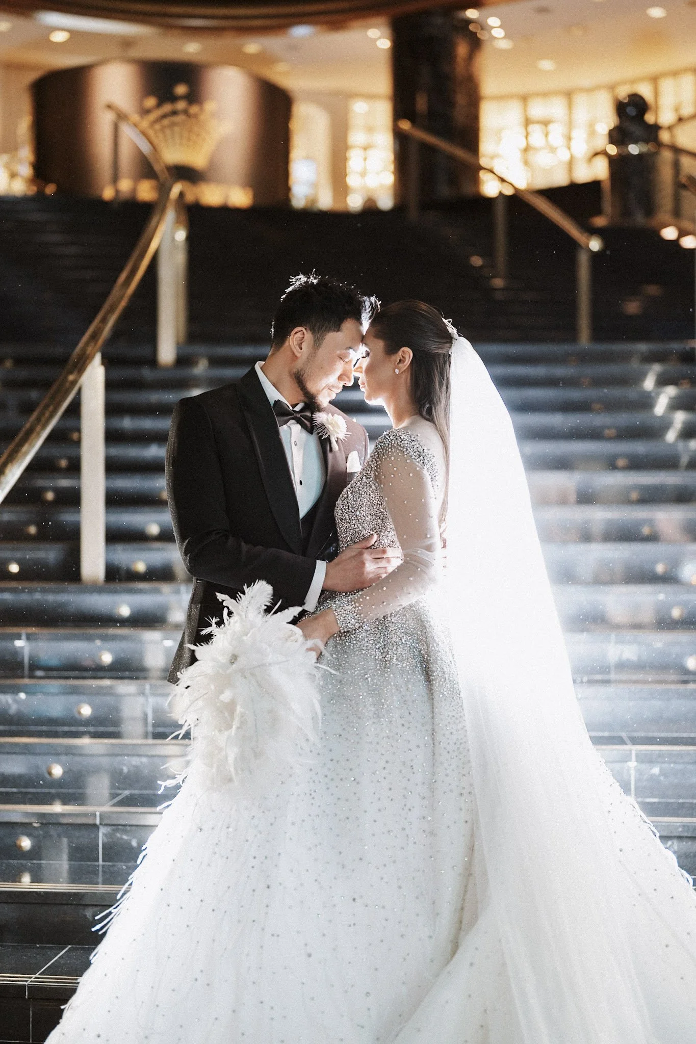 Newlyweds kissing on a grand interior staircase