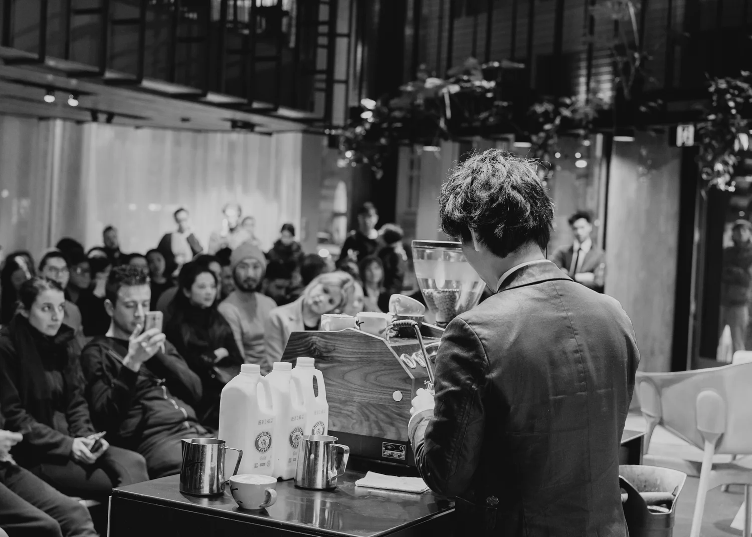 Barista demonstrating coffee preparation to a seated audience