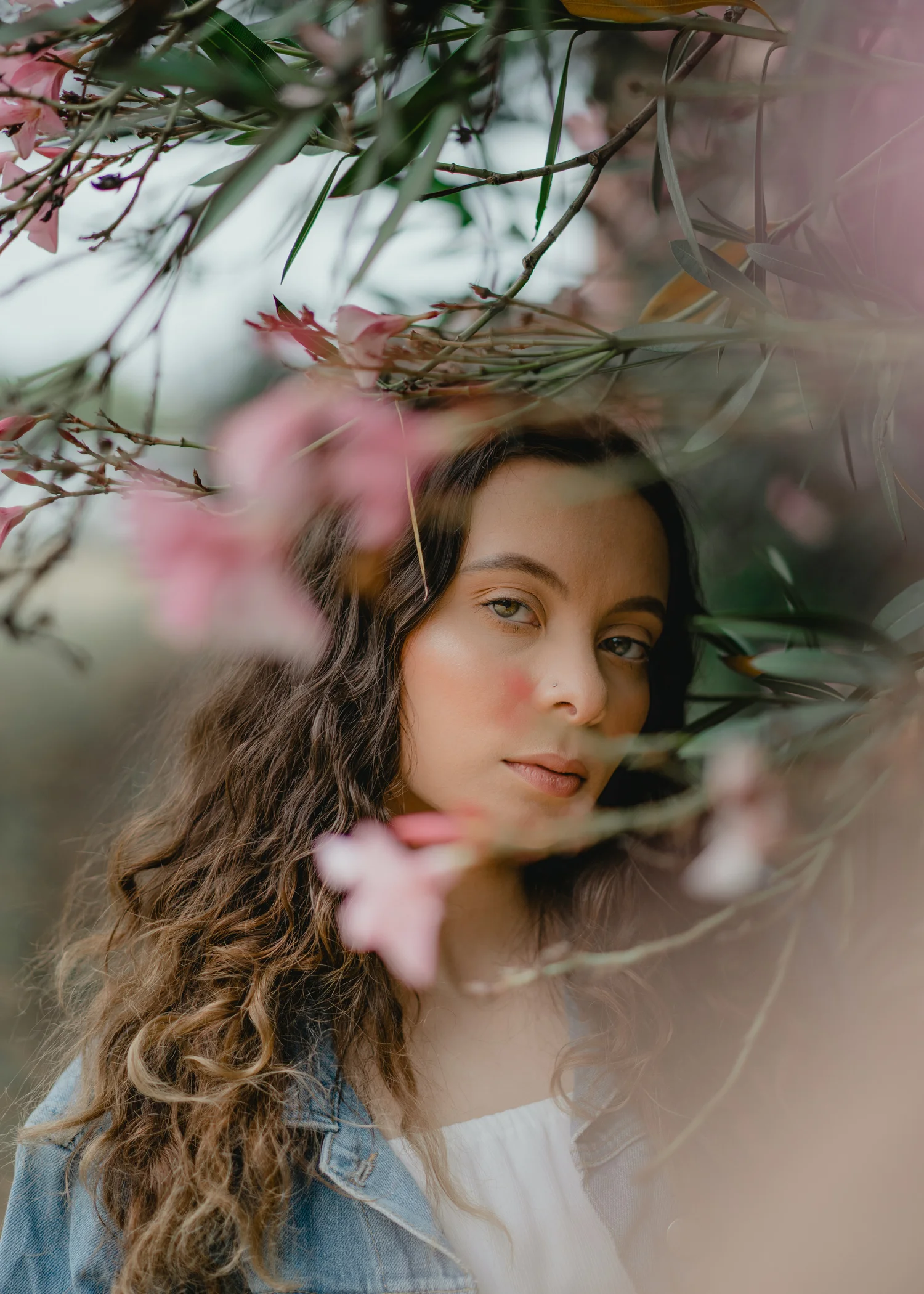 Portrait of a woman framed by pink blossoms