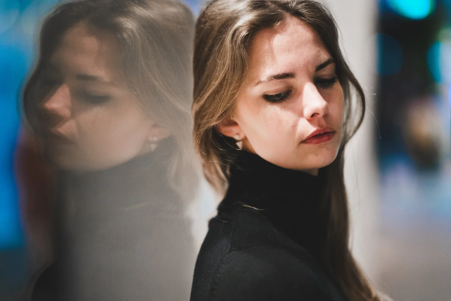 Reflected double portrait of a woman against city lights