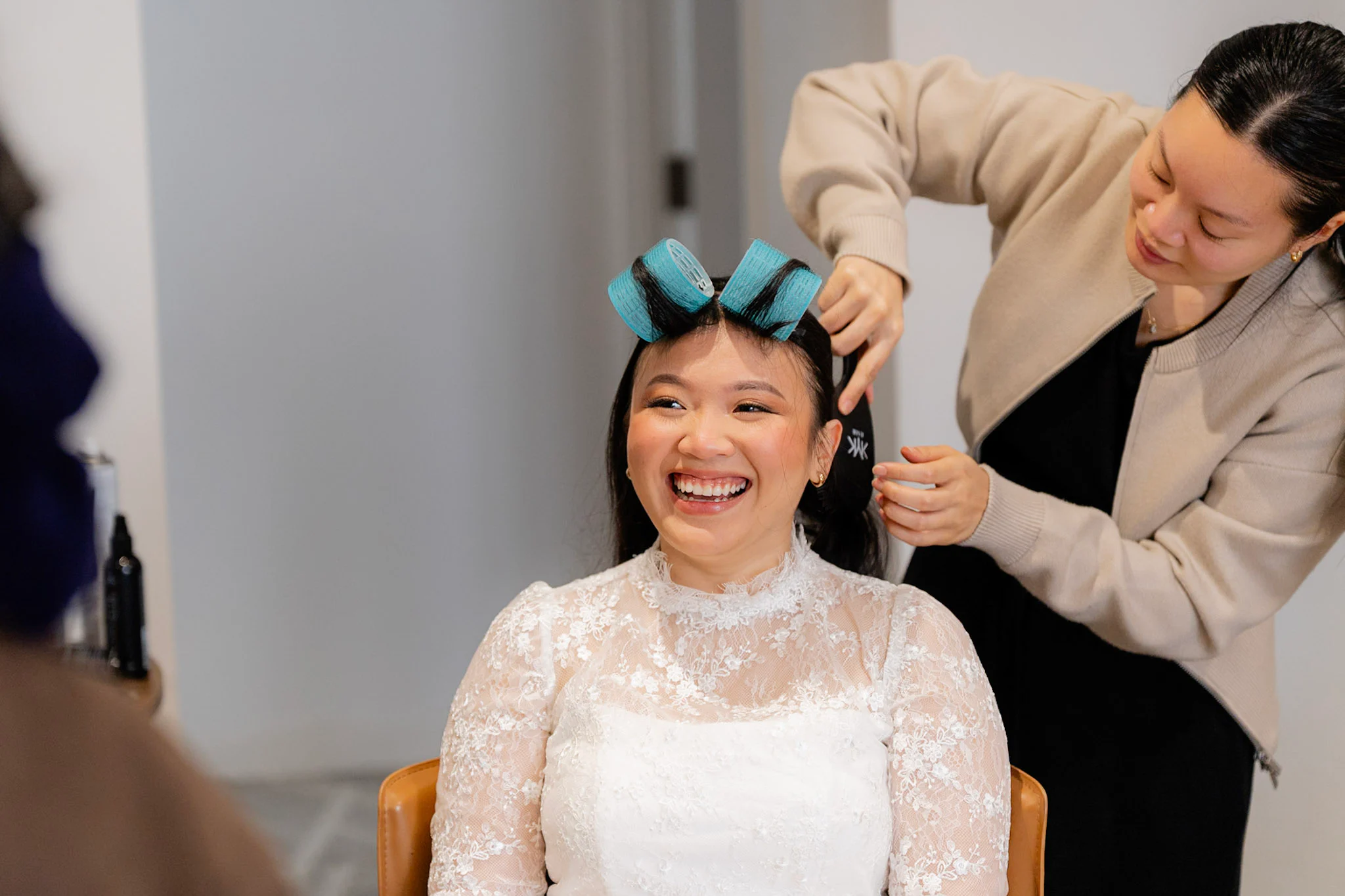 Joy laughing while her hair is styled in curlers