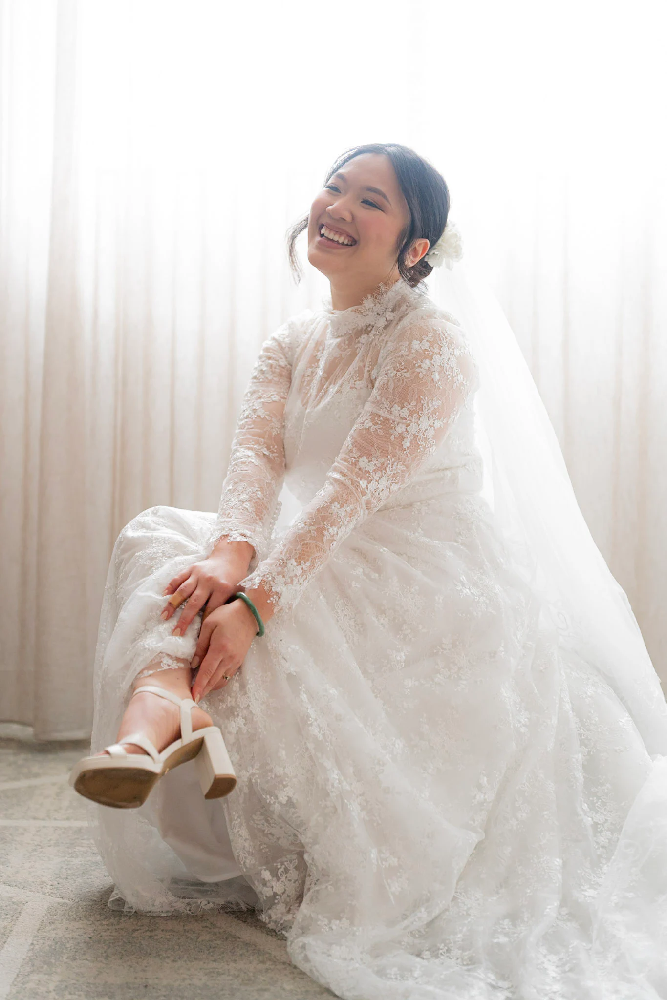 Joy laughing as she puts on her wedding shoes
