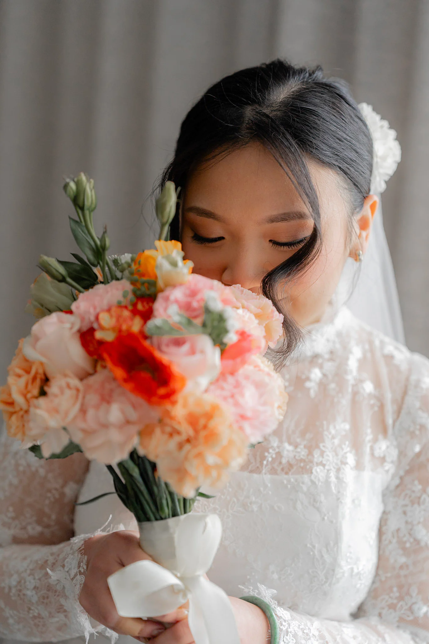 Joy smiling behind her colourful wedding bouquet