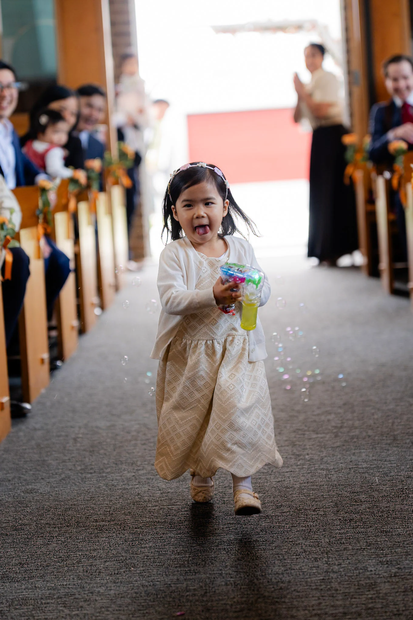A flower girl running happily down the church aisle