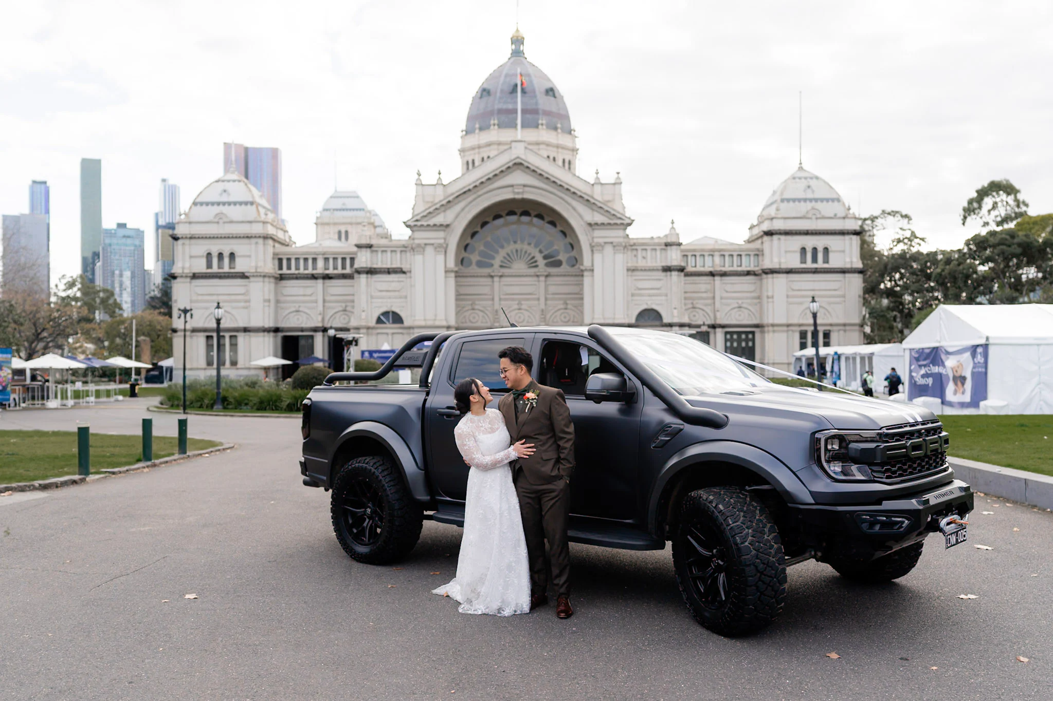 Ron and Joy standing with their black truck before a Melbourne landmark