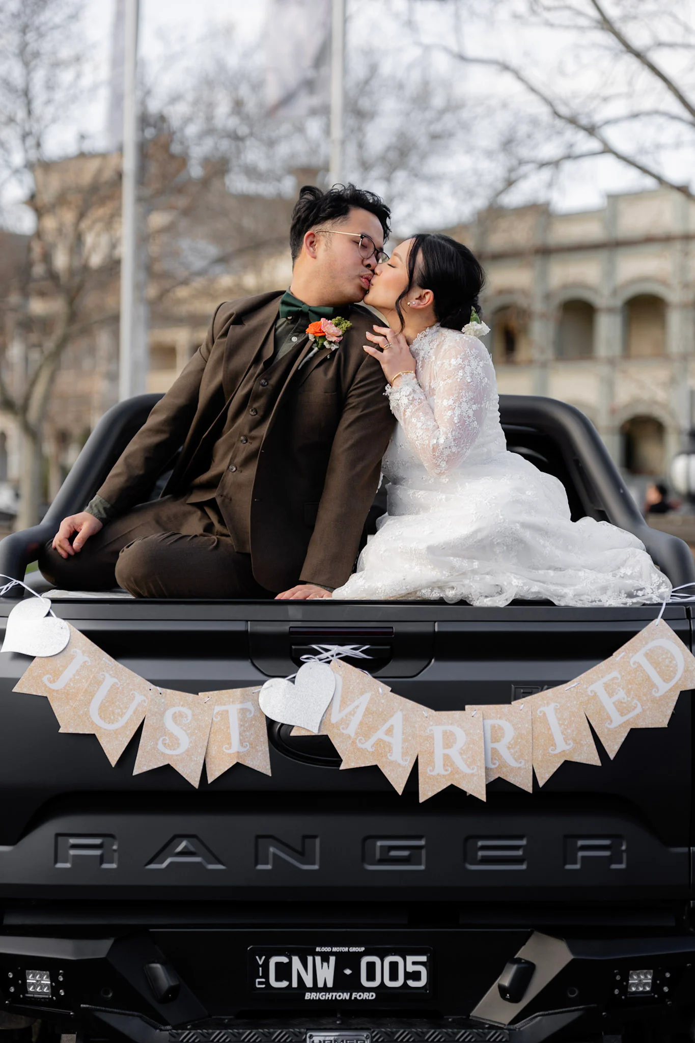Ron and Joy kissing while sitting on the back of their truck