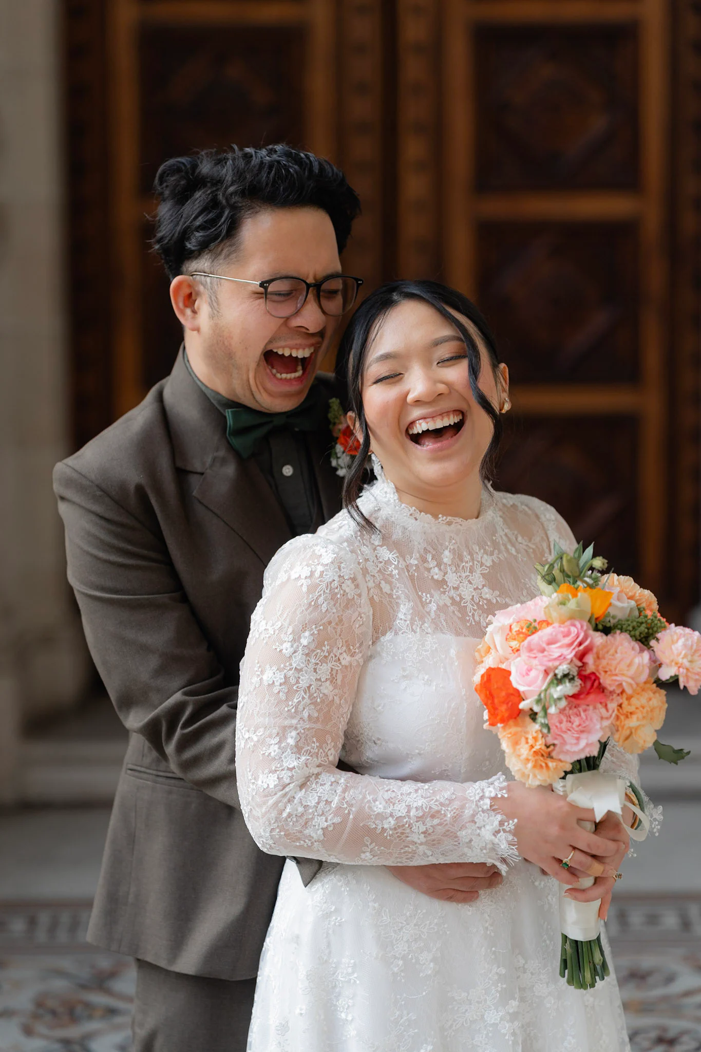 Ron and Joy laughing together between stone columns