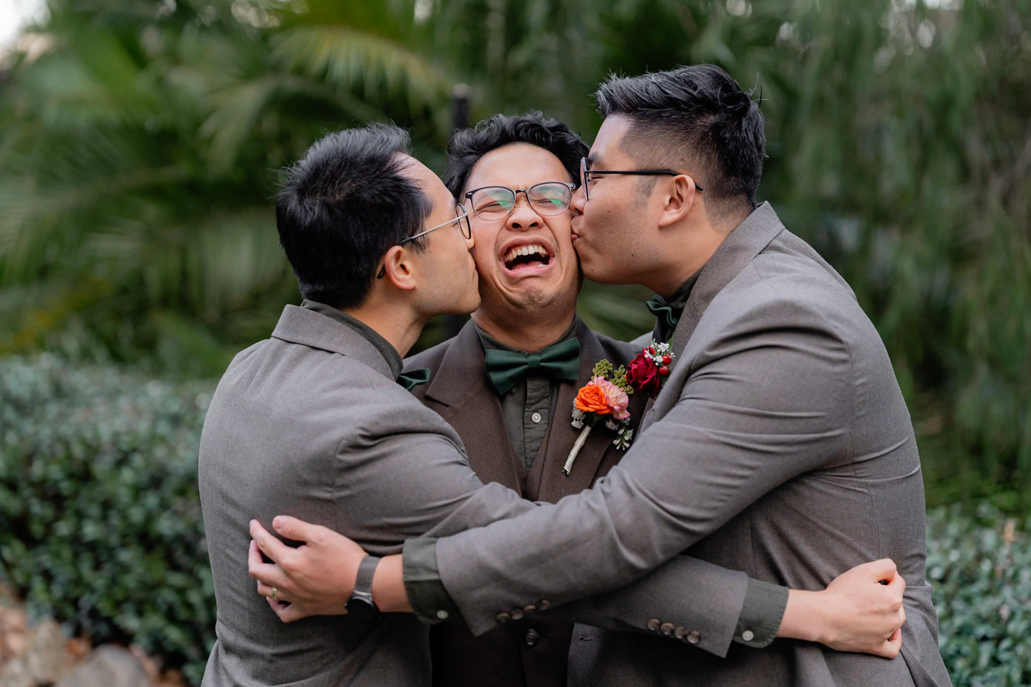 Ron's groomsmen kissing his cheeks during portraits