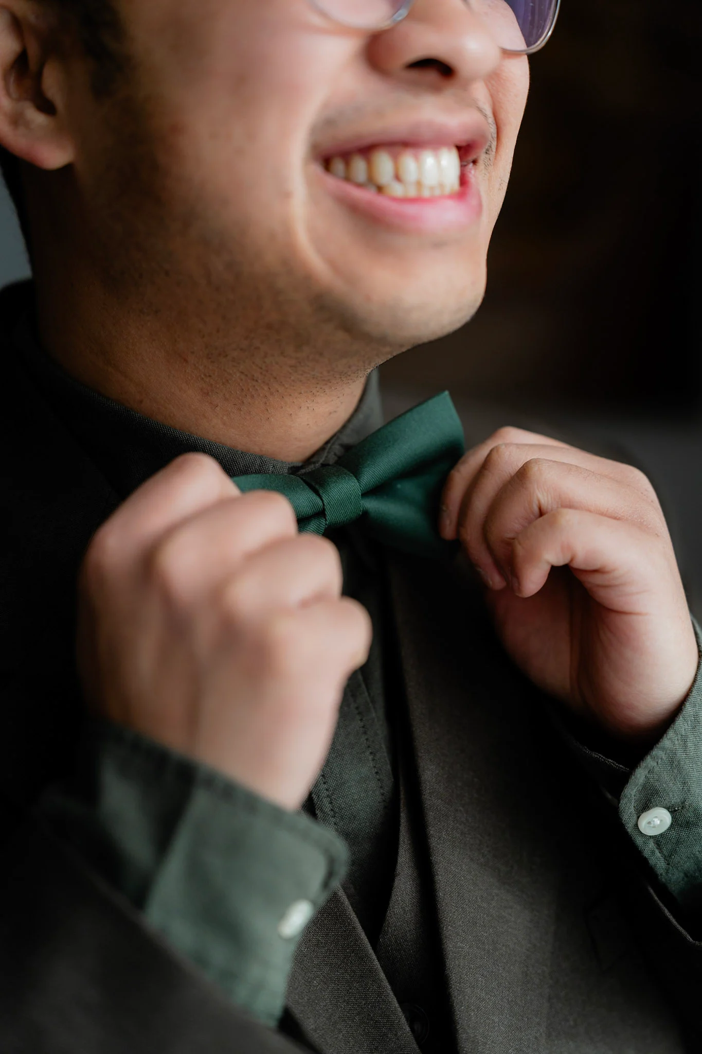 Ron smiling as he adjusts his green bow tie