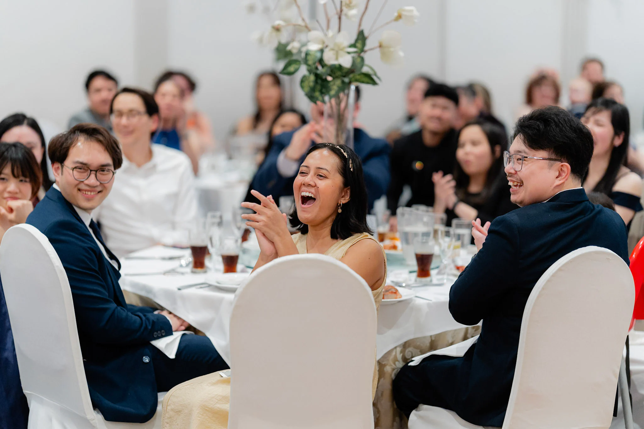 Wedding guests laughing together during the speeches
