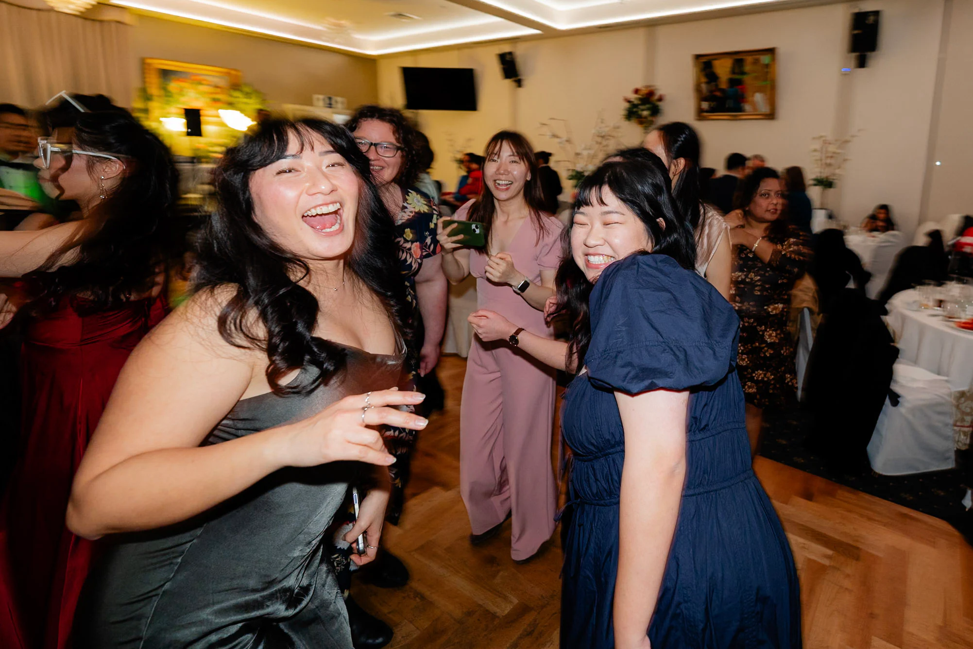 Friends laughing together on the wedding dance floor