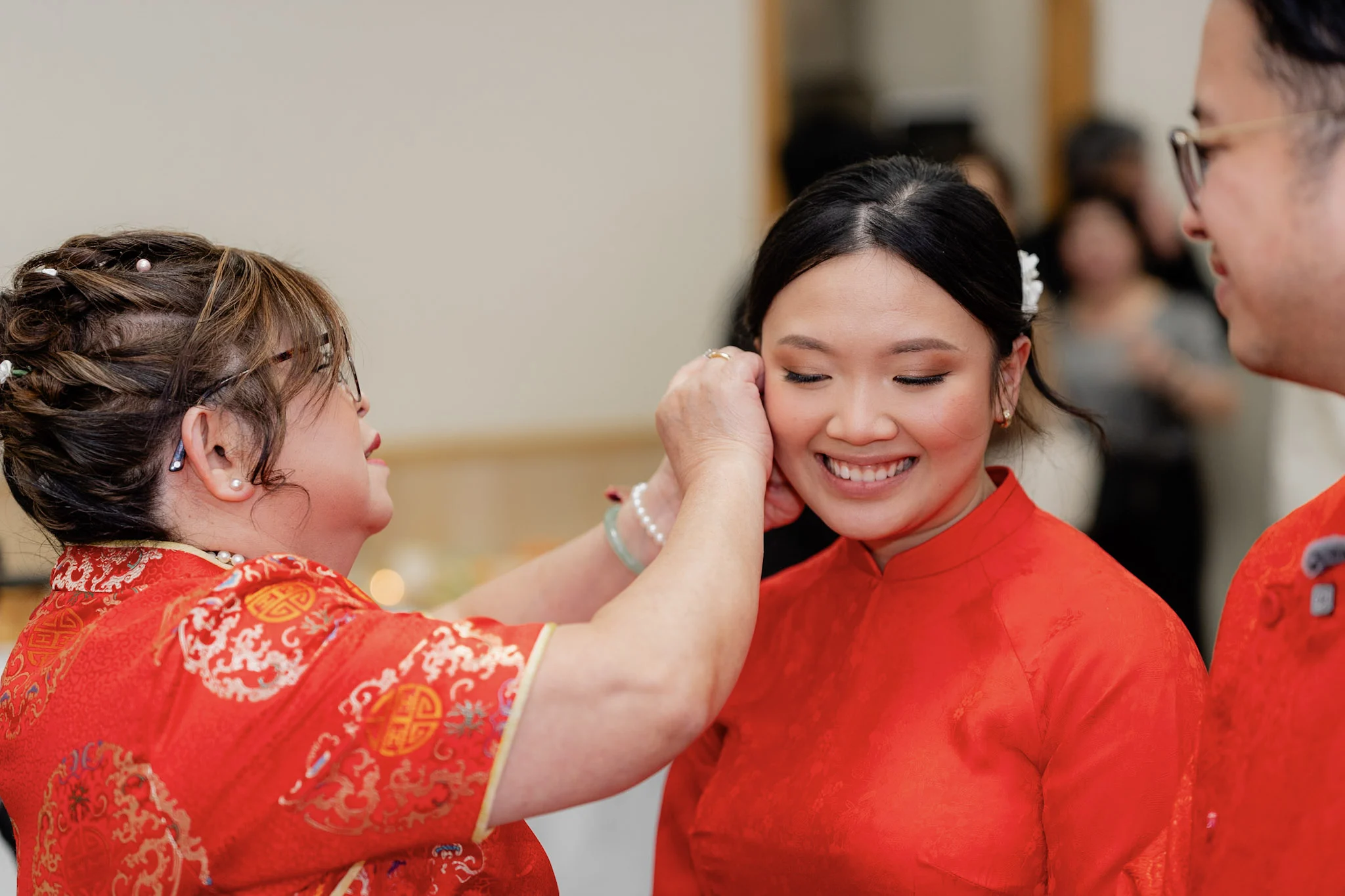 A family elder fastening jewellery for Joy during the tea ceremony