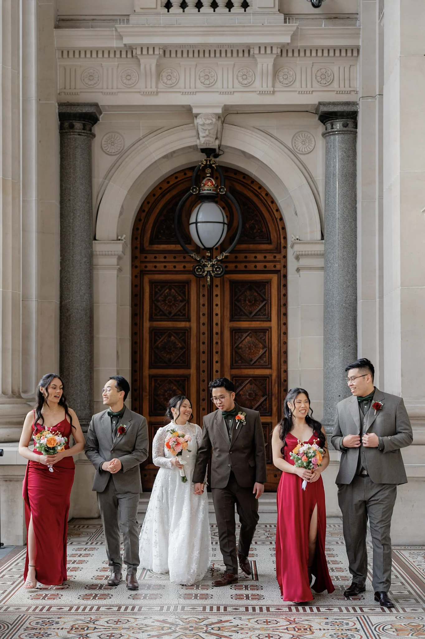 Ron, Joy and their bridal party walking between grand stone columns