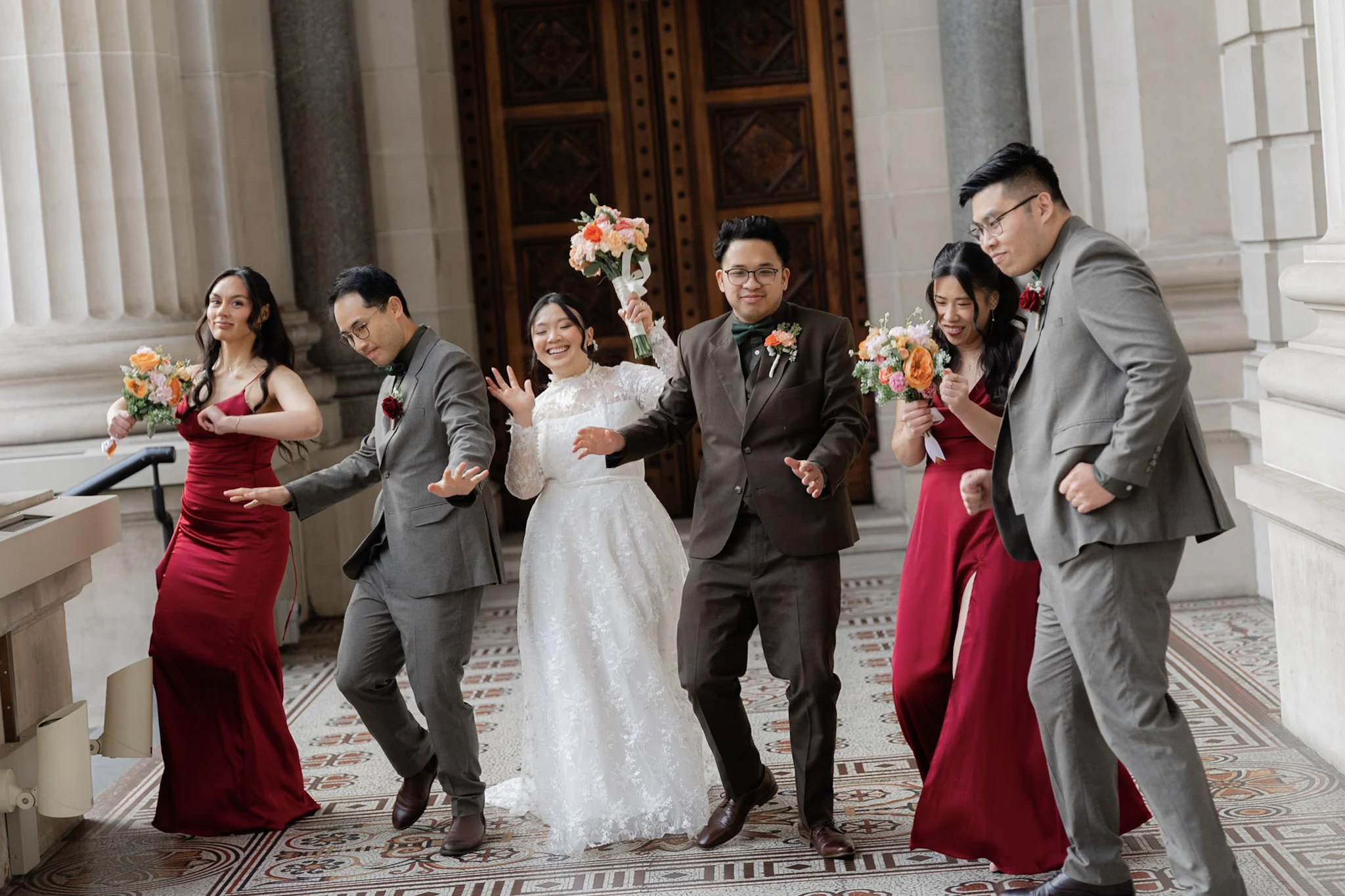 The wedding party laughing and moving together during portraits