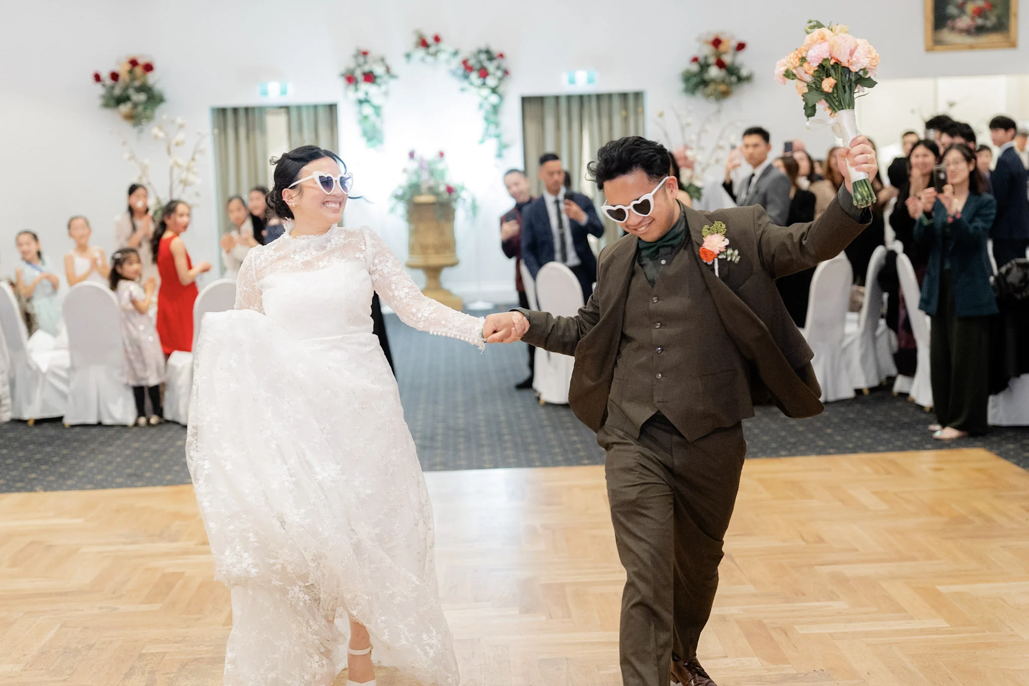 Ron and Joy dancing into their reception in heart-shaped sunglasses