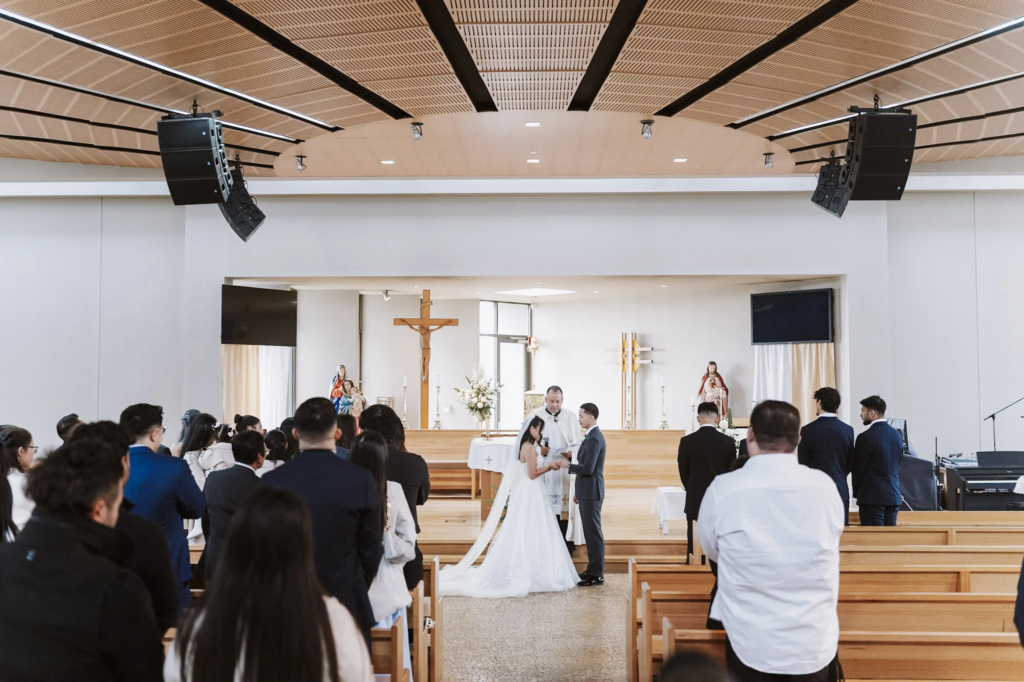 A wide view of the church with guests gathered around the couple