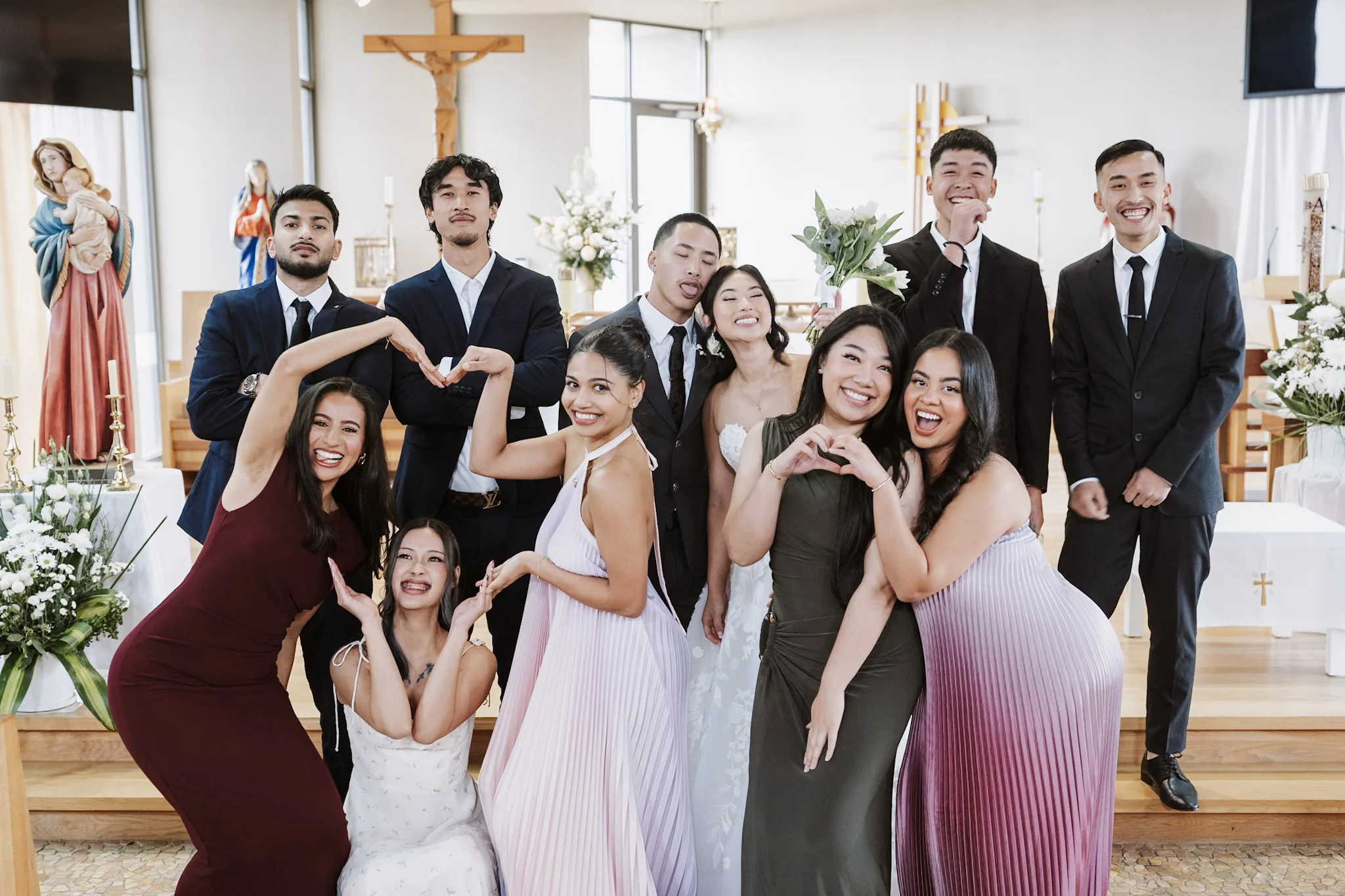 The wedding party pulling playful poses around Kevin and Tee