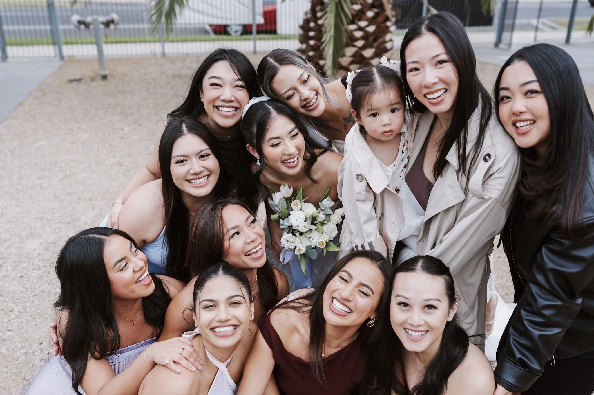Friends crowding together around Tee for a joyful close group photograph