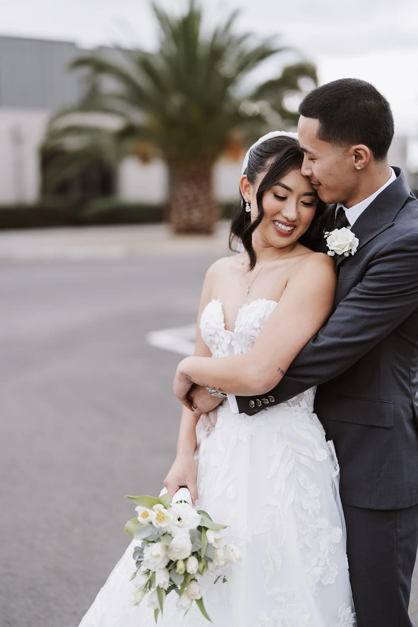 Kevin embracing Tee from behind outside the church
