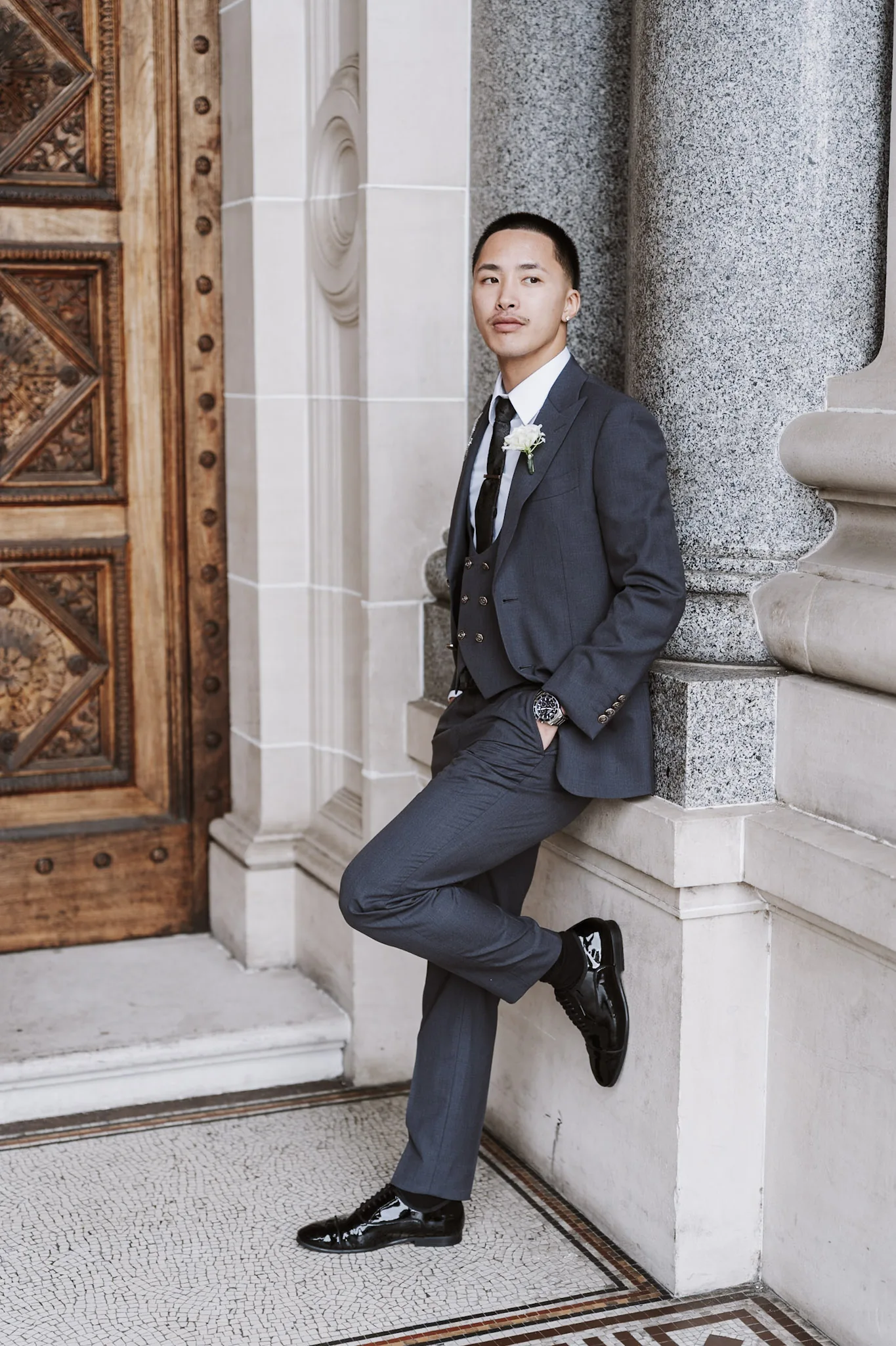 Kevin leaning casually against a stone column
